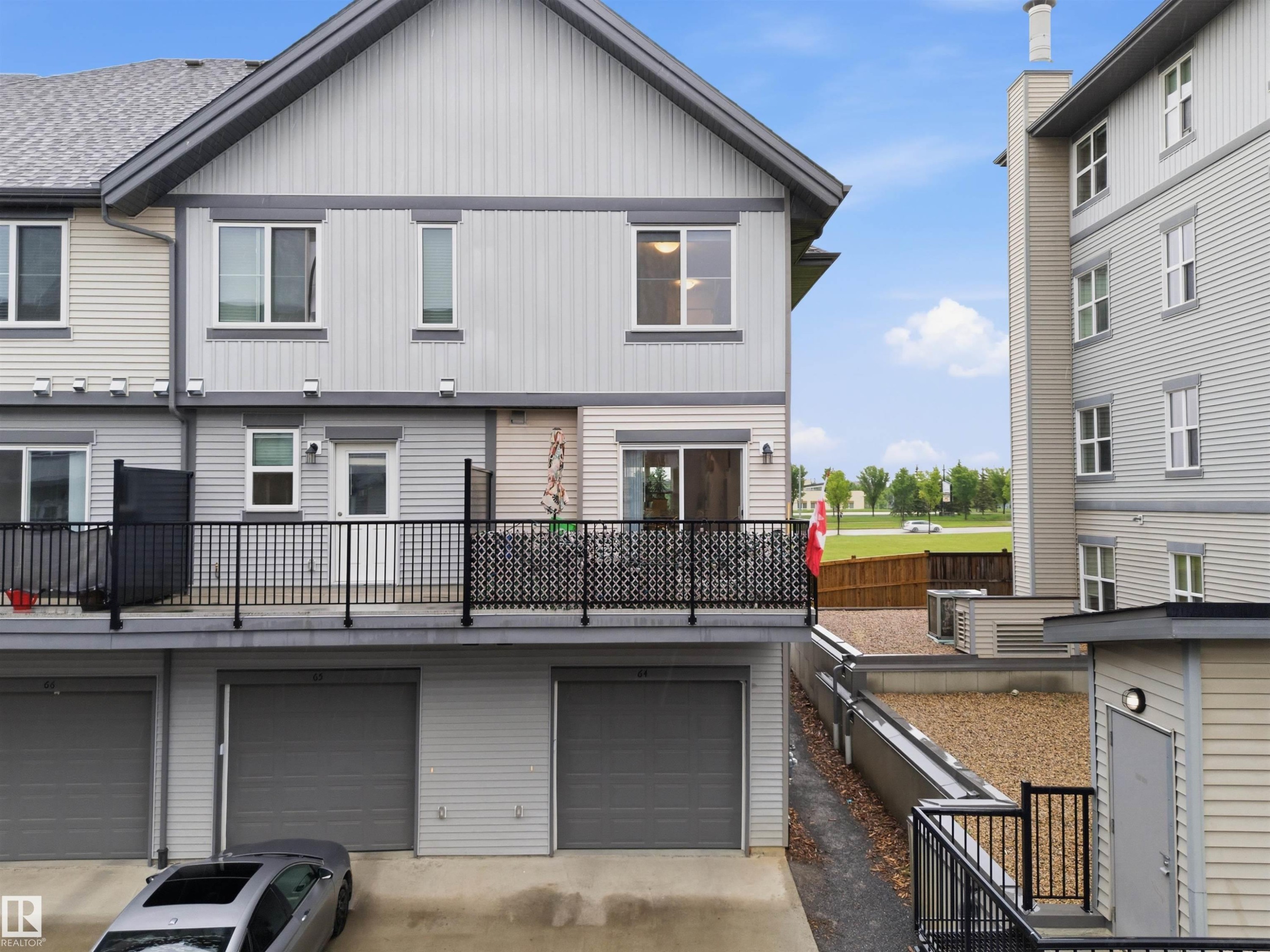 Multi-level residence featuring contemporary siding, private balcony, and an attached garage with overhead door - 64 655 Watt Boulevard, Edmonton, AB