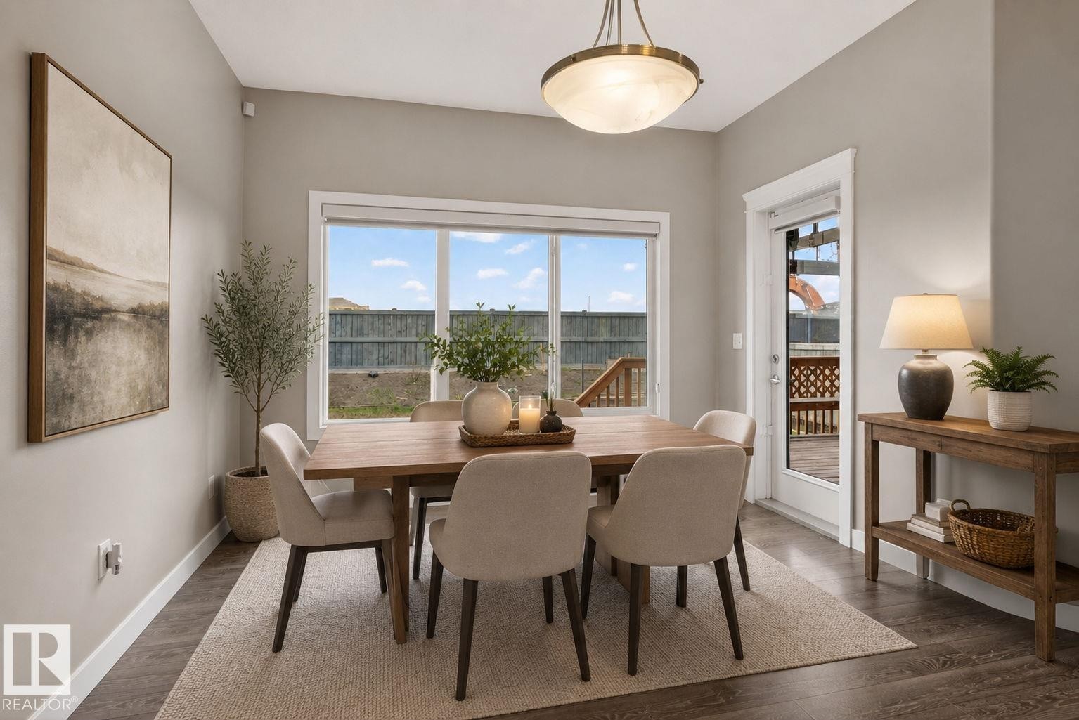 Dining area featuring a large window, a glass-paneled exterior door, wood-finish flooring, and a flush-mount ceiling light fixture - 7341 Armour Crescent, Edmonton, AB - Indoor Photo Showing Dining Room