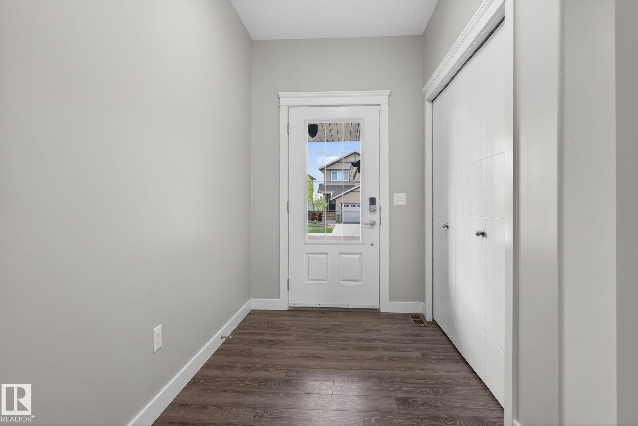Entryway featuring wood-finish flooring, light gray walls, and white baseboards - 7341 Armour Crescent, Edmonton, AB - Indoor Photo Showing Other Room