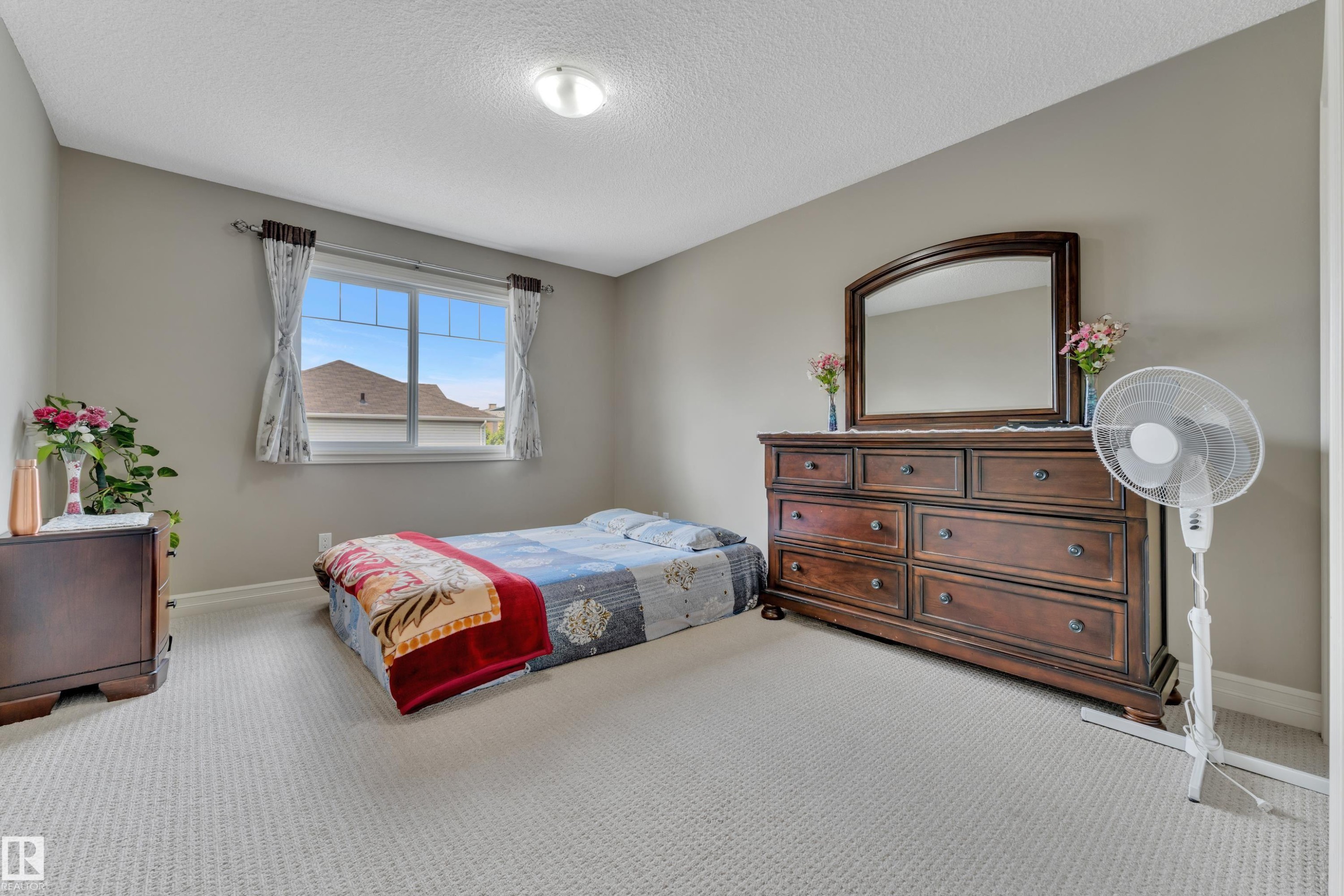 Carpeted room with a double-paned window, neutral wall paint, and a ceiling-mounted light fixture - #24 655 Tamarck Rd Nw, Edmonton, AB - Indoor Photo Showing Bedroom