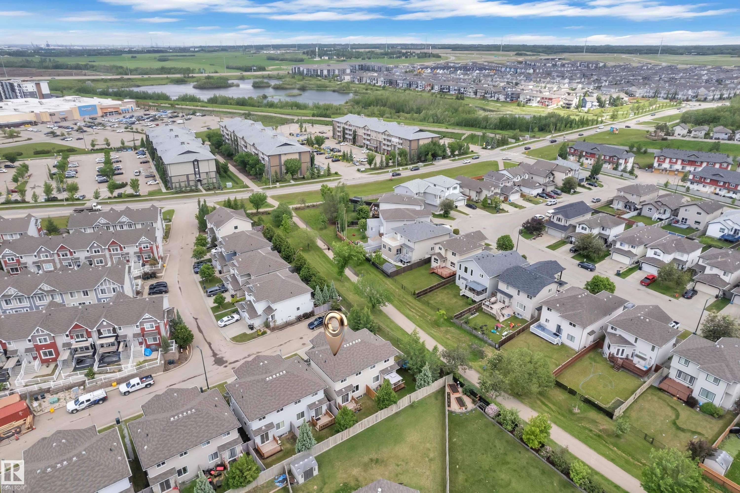 Aerial perspective showcasing the residential neighborhood layout with a mix of detached homes and townhouses - #24 655 Tamarck Rd Nw, Edmonton, AB - Outdoor With View