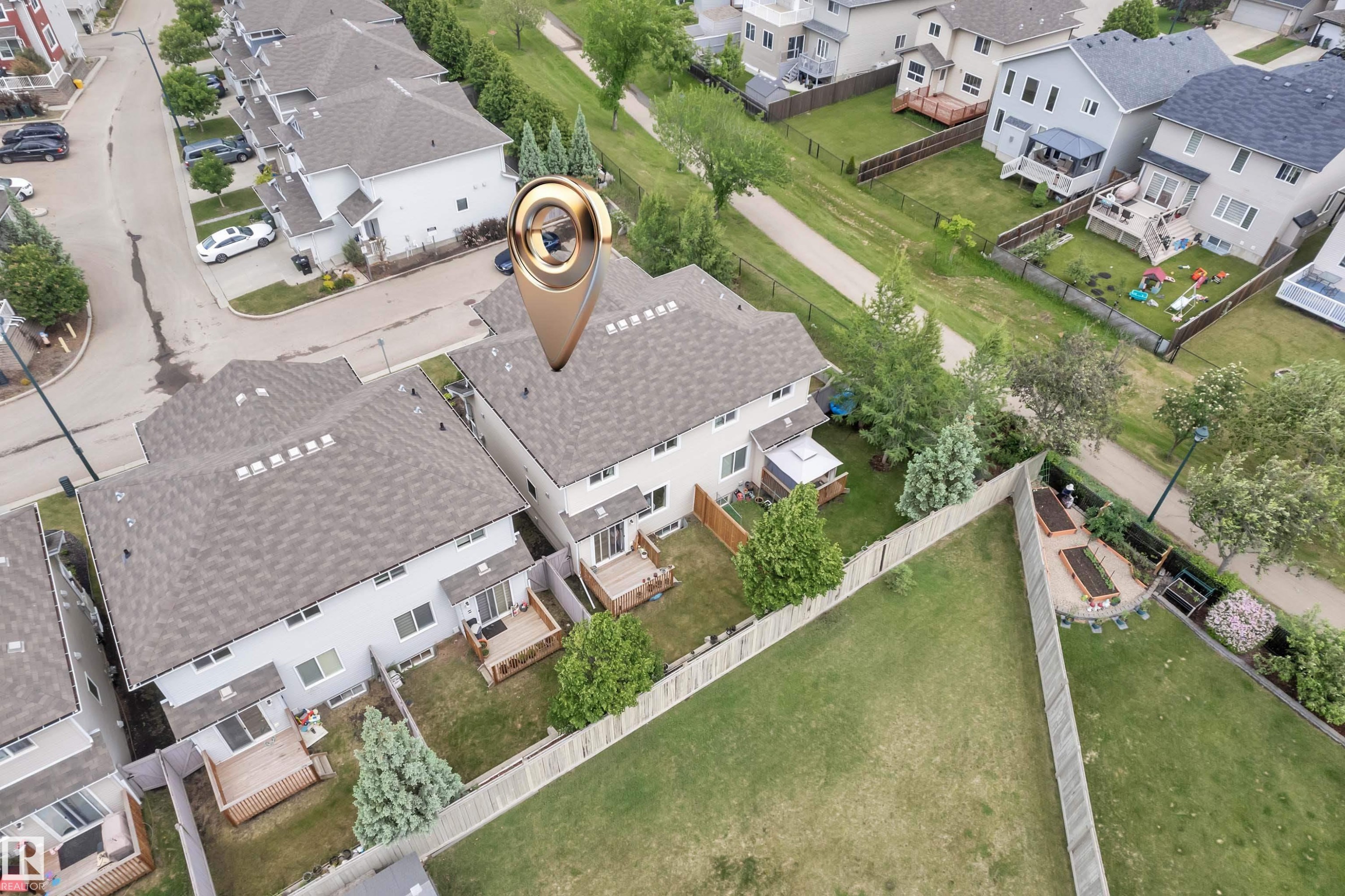 Two-story exterior with light-colored siding and a dark shingled roof - #24 655 Tamarck Rd Nw, Edmonton, AB - Outdoor With View