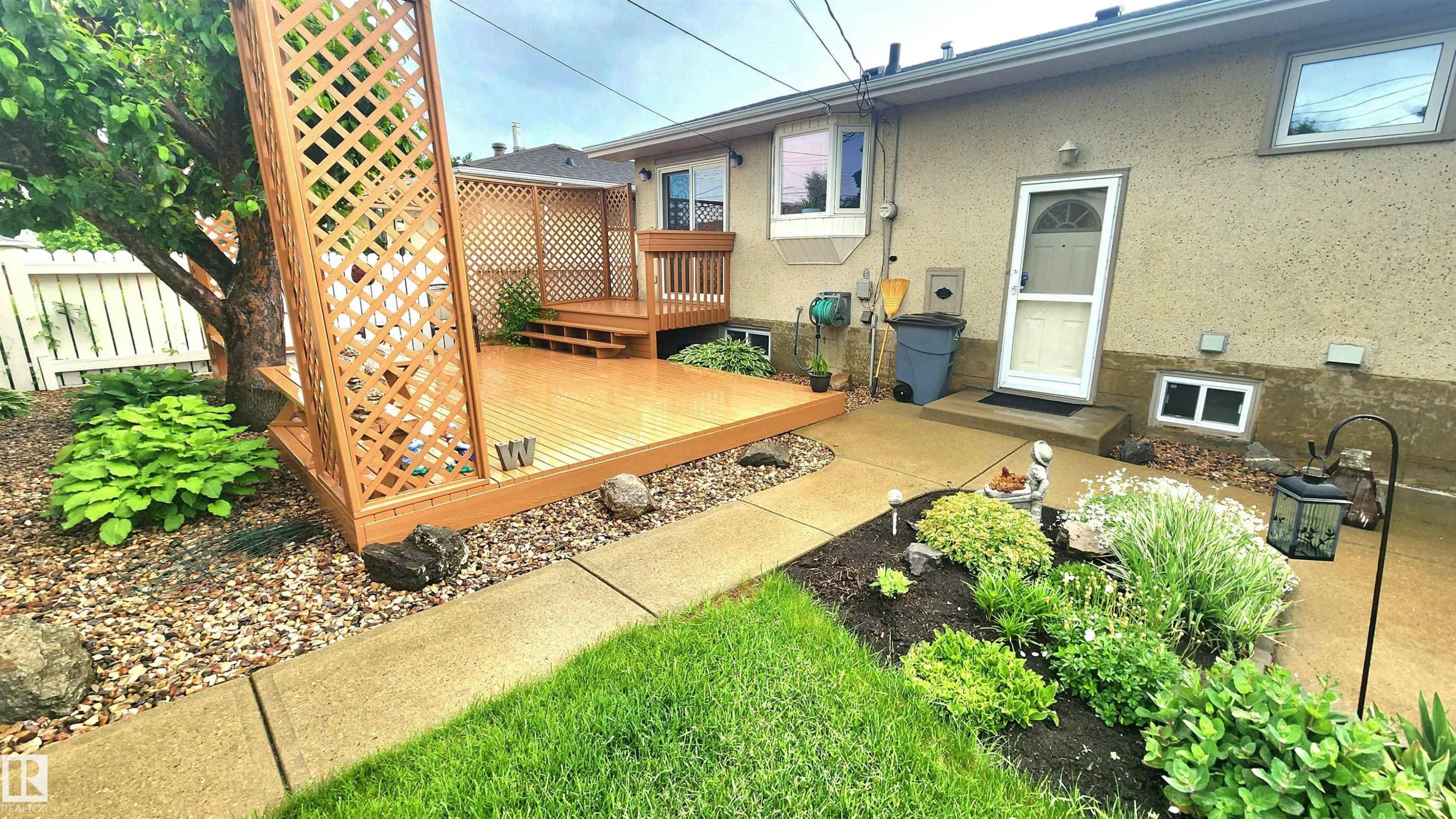 Outdoor living space featuring a wood-finish deck with privacy lattice - 13307 Delwood Road, Edmonton, AB