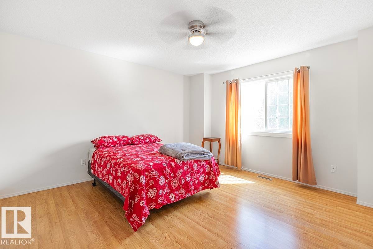 Light-filled interior space featuring wood-finish flooring, a window with curtains, and a ceiling fan with integrated lighting - 44 9630 176 Street, Edmonton, AB