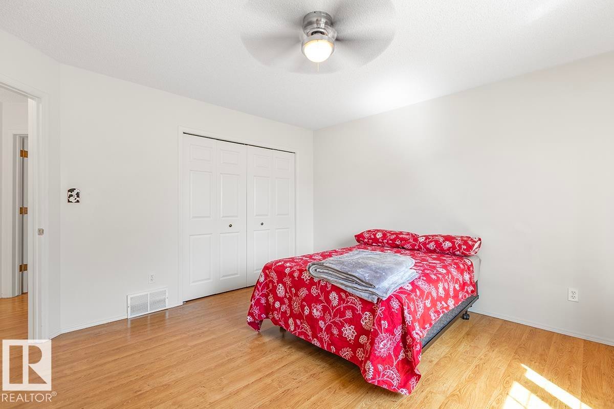 Bedroom featuring wood-finish flooring, white walls, and a ceiling fan with integrated lighting - 44 9630 176 Street, Edmonton, AB
