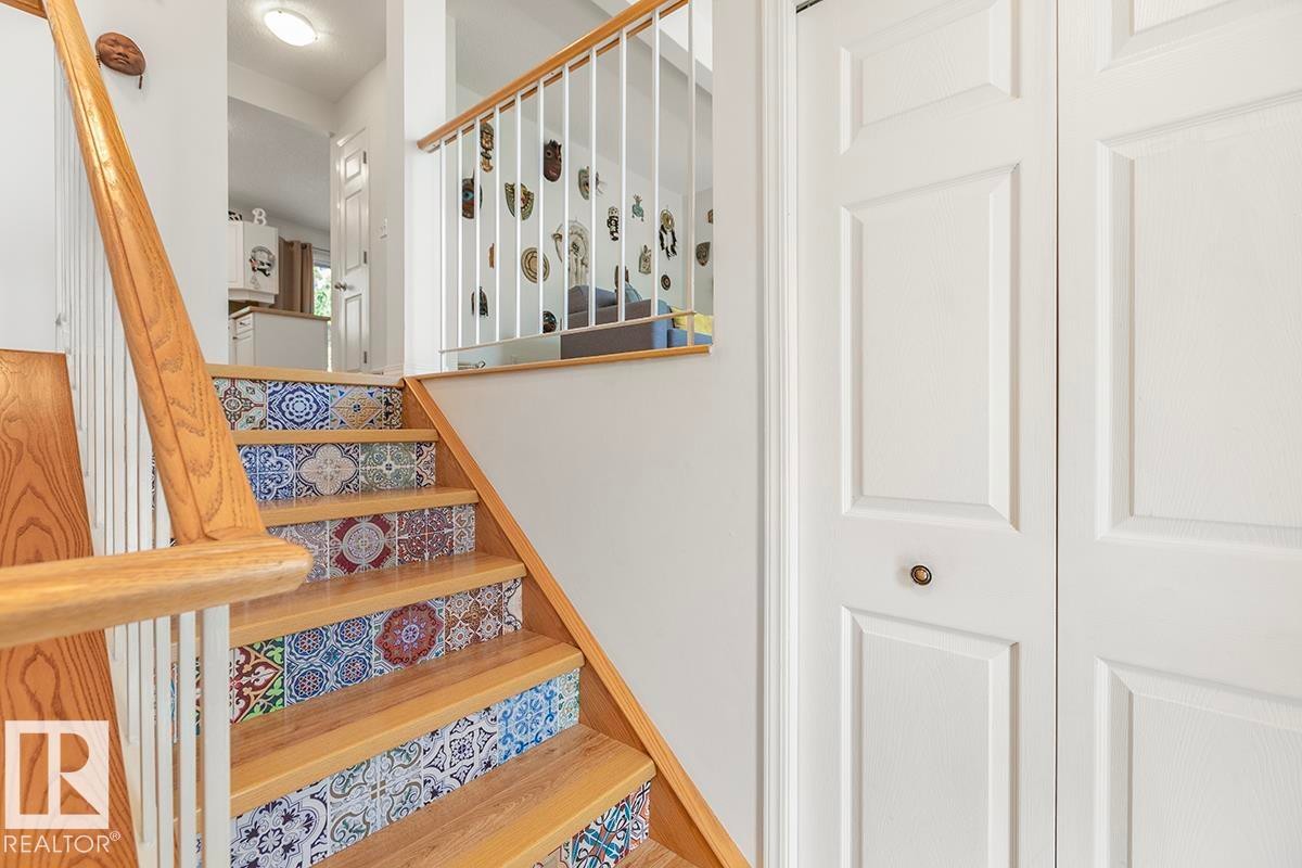 Staircase featuring wood treads and risers with decorative tile accents - 44 9630 176 Street, Edmonton, AB