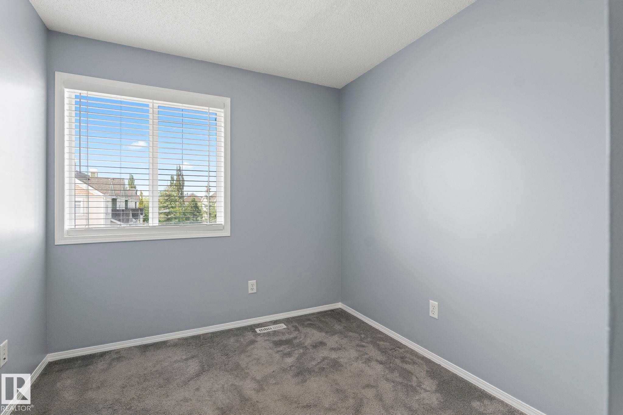 Interior space featuring light gray walls, white trim, and gray carpet - 7118 19A, Edmonton, AB - Indoor Photo Showing Other Room