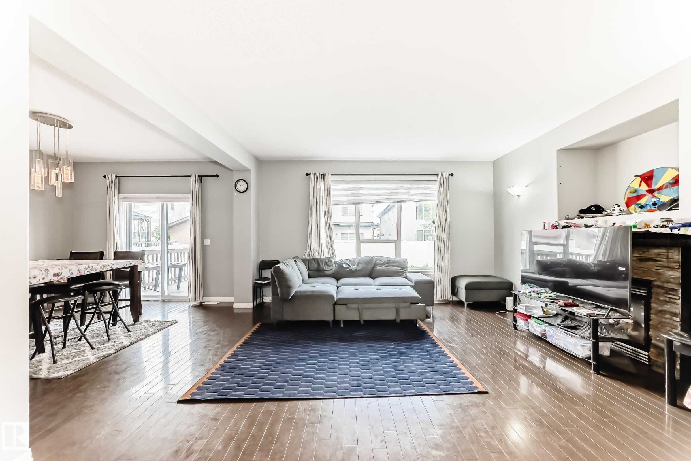 Open-concept living area featuring wood-finish flooring, recessed wall niche, and patio door access - 16720 61 Street Nw, Edmonton, AB - Indoor Photo Showing Living Room