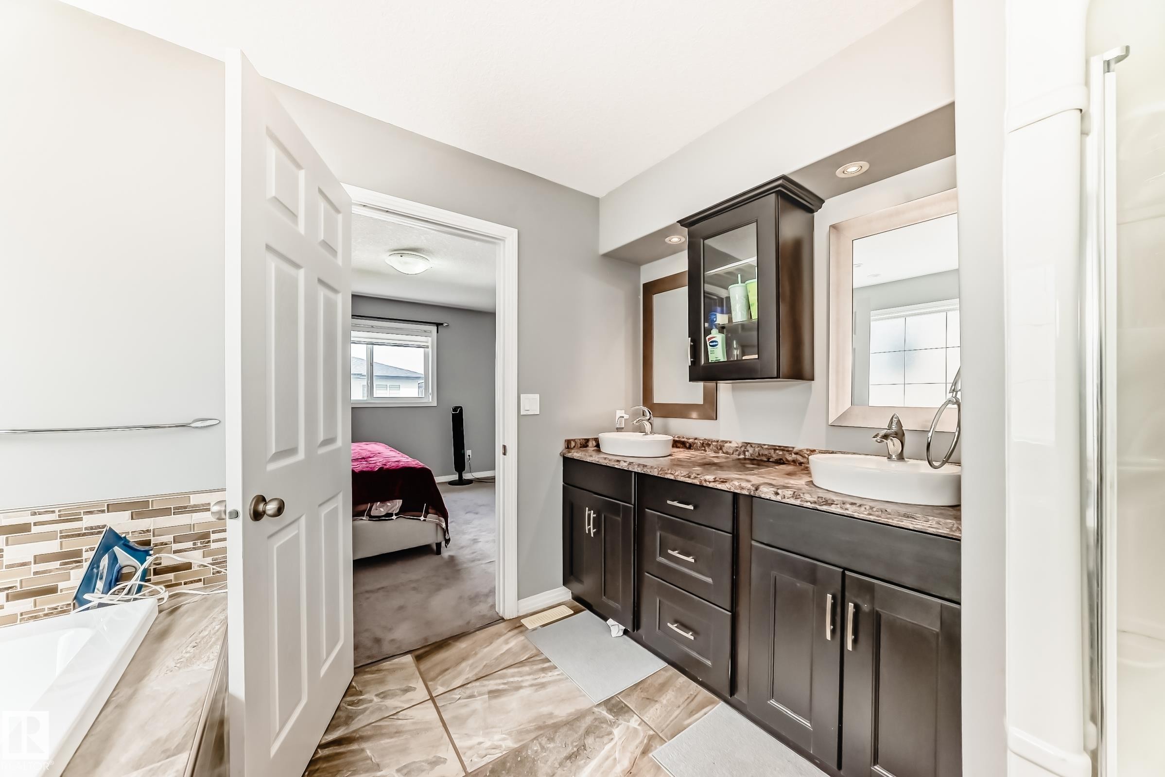Double vanity with dark wood-finish cabinetry, countertop, and vessel sinks - 16720 61 Street Nw, Edmonton, AB - Indoor Photo Showing Bathroom