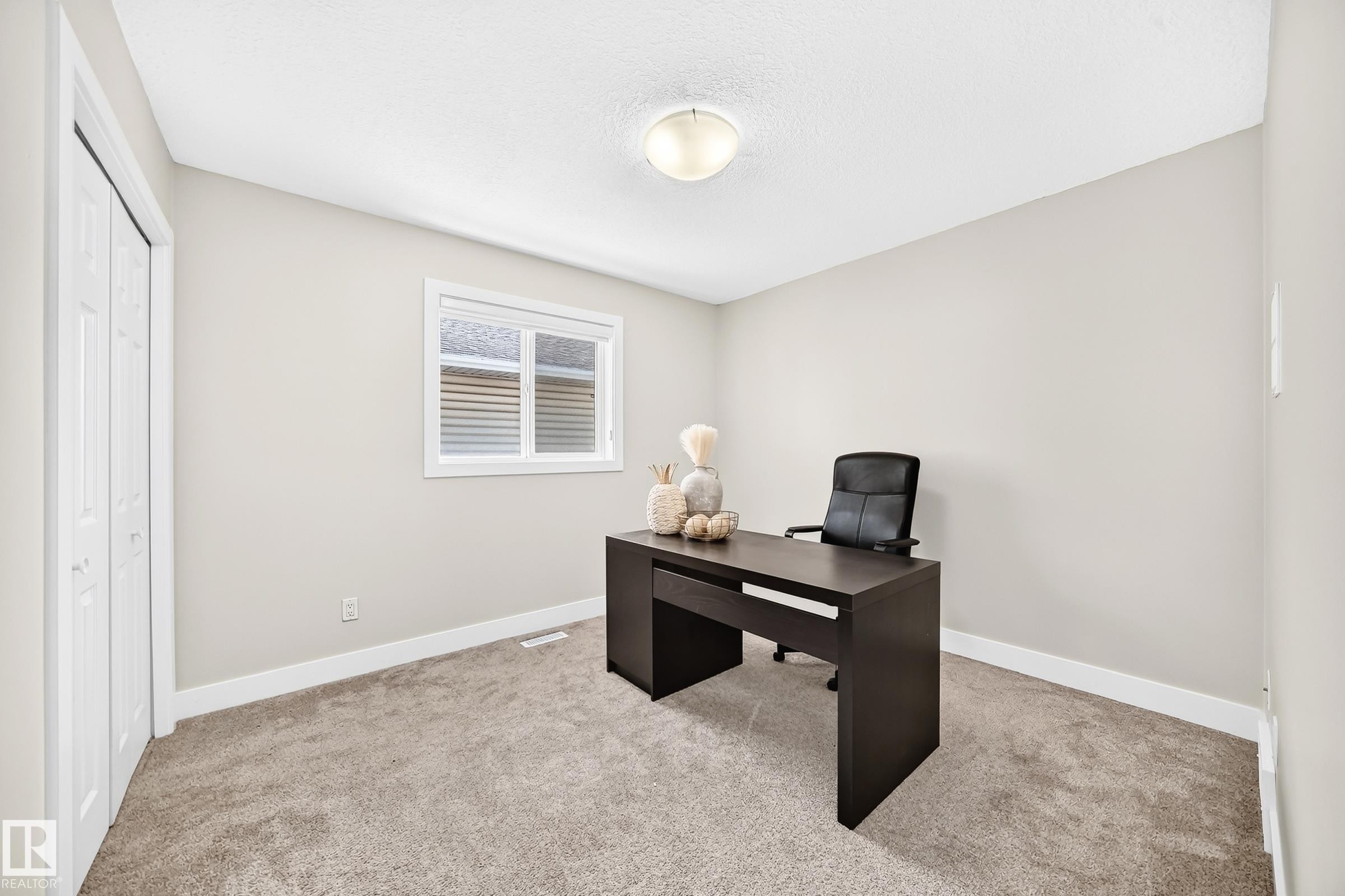 Neutral-toned room featuring light-colored walls and plush carpet flooring - 16124 76 Street, Edmonton, AB