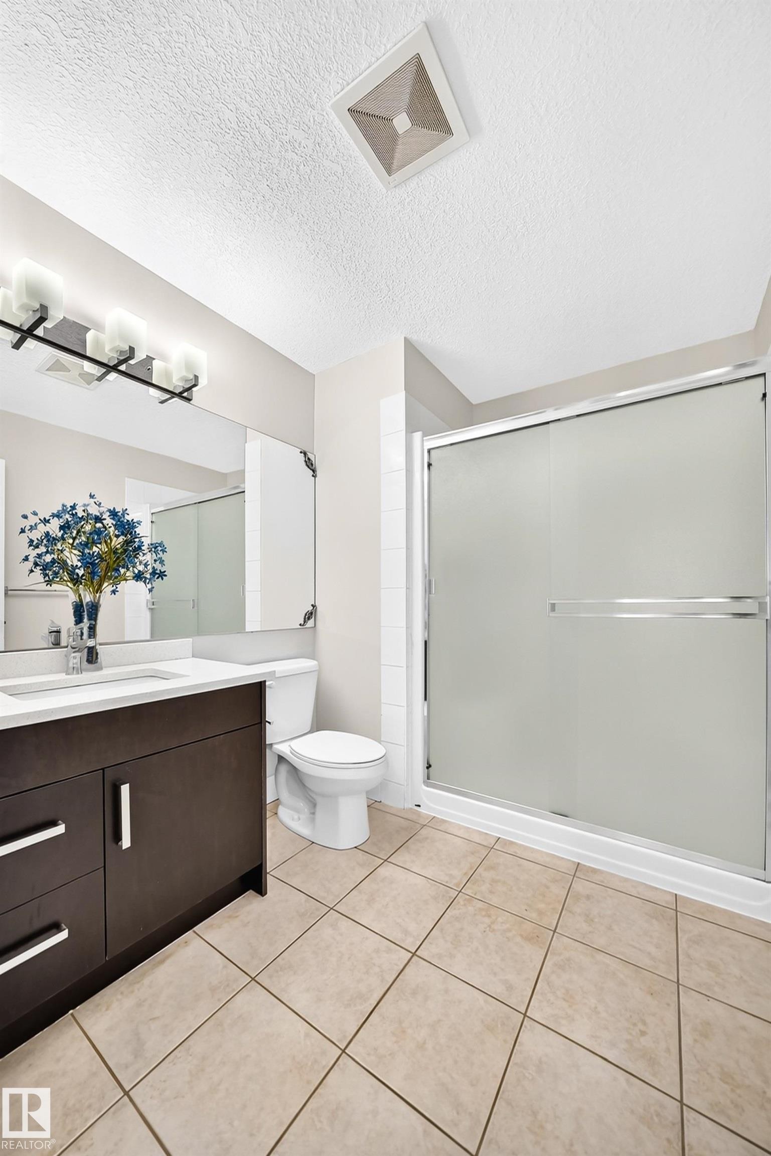 Bathroom with a dark wood-finish vanity, white countertop, and rectangular sink - 16124 76 Street, Edmonton, AB