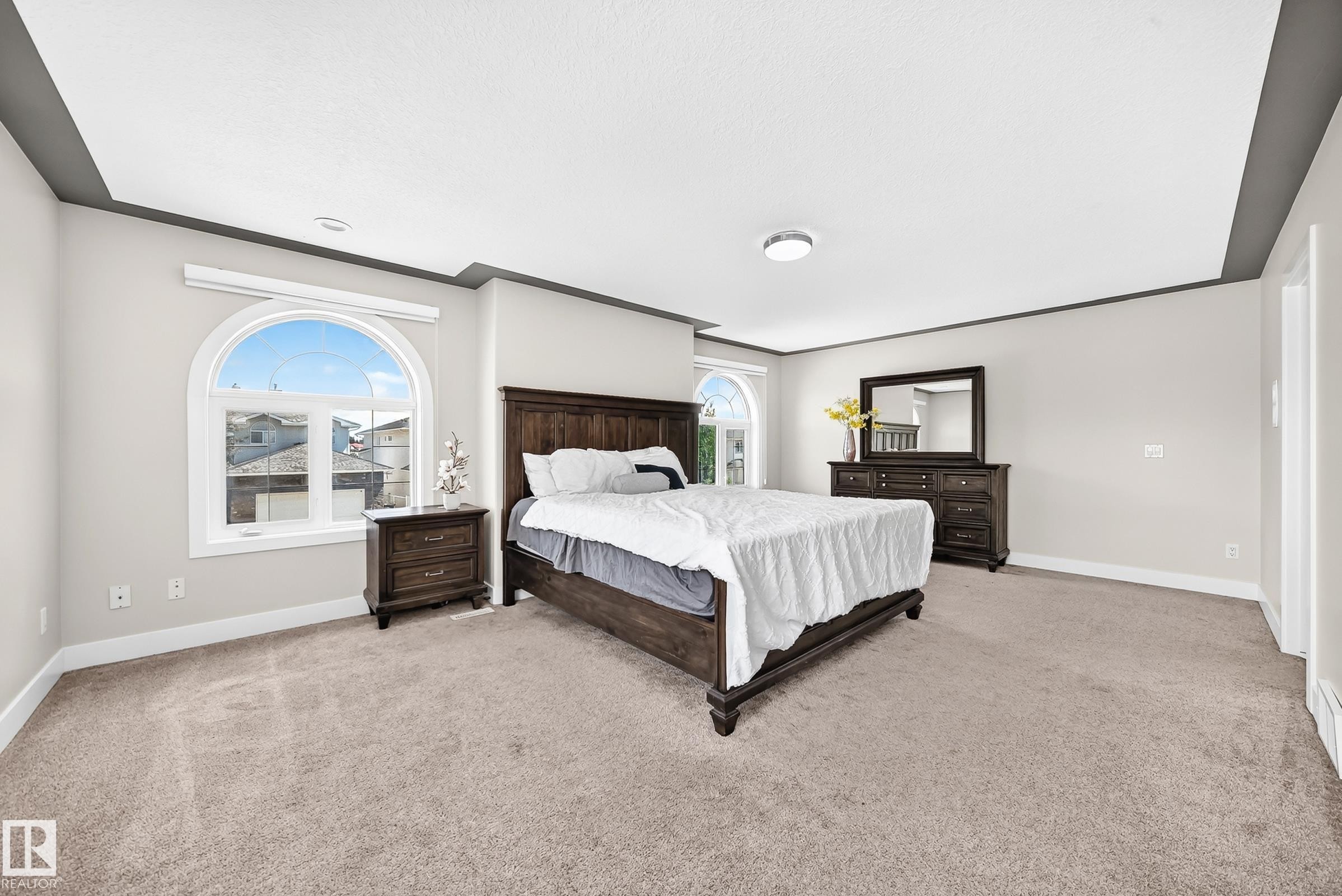 Recessed ceiling with gray trim, arched window, wall-to-wall carpeting, and light gray wall paint - 16124 76 Street, Edmonton, AB