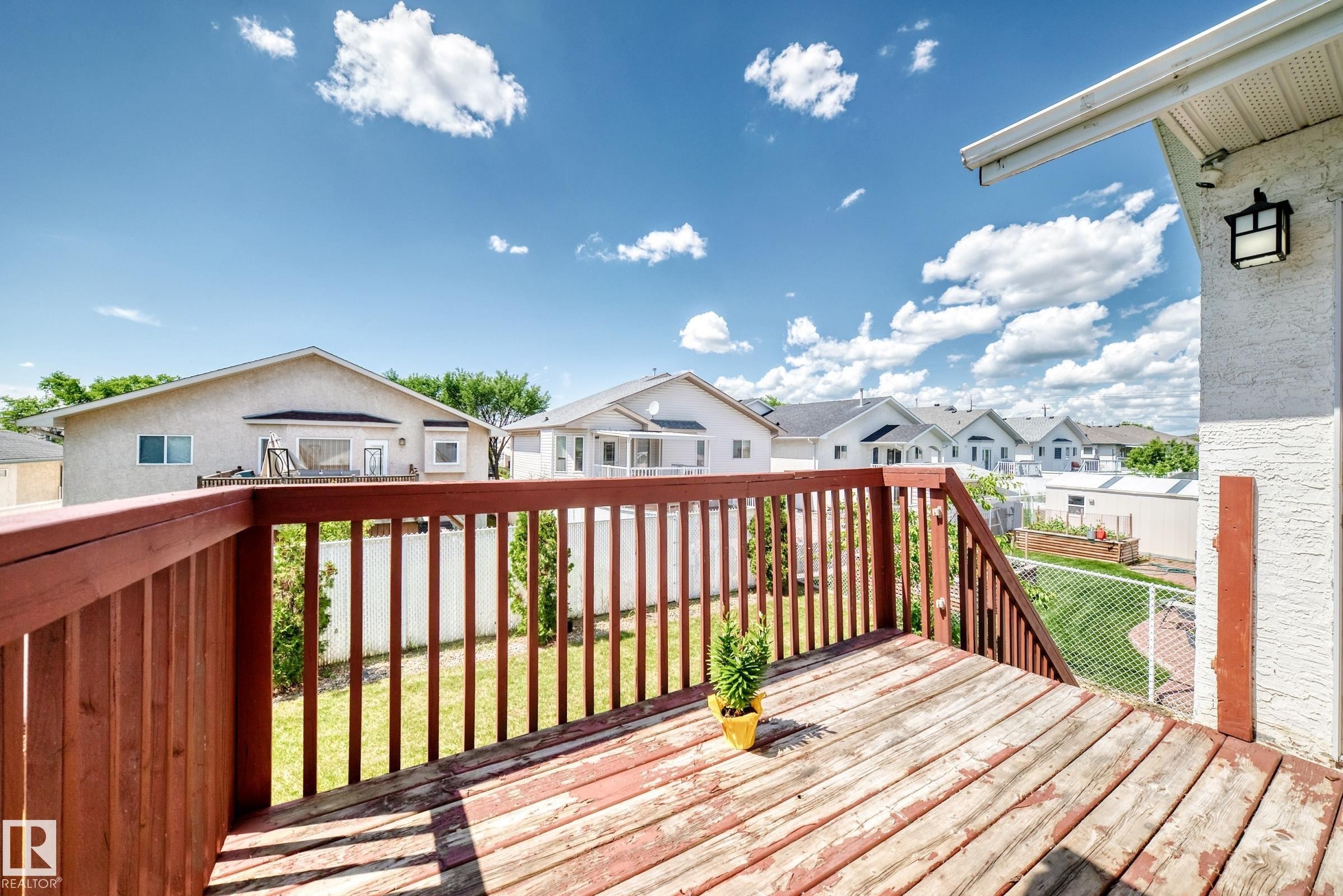 Raised wooden deck featuring a railing system and steps - 16124 76 Street, Edmonton, AB