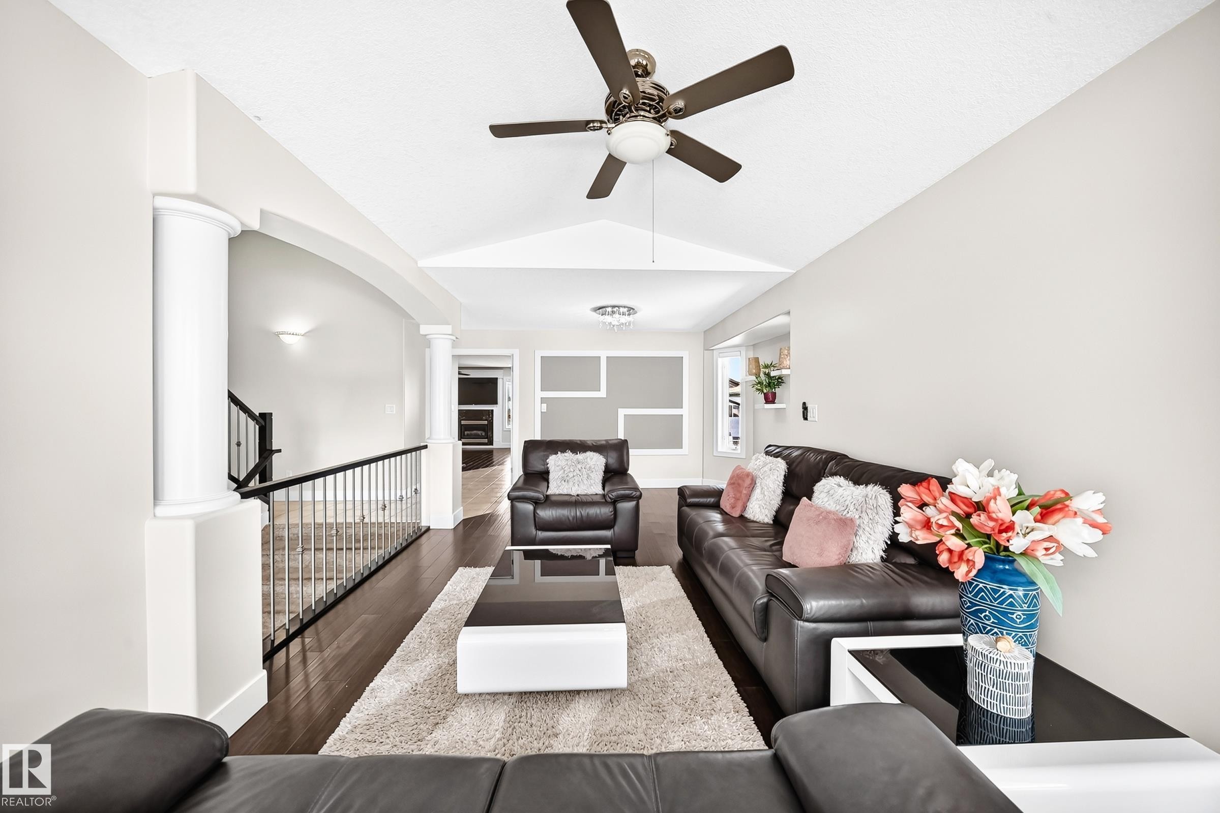 Living area featuring vaulted ceilings, wood-finish flooring, and a ceiling fan - 16124 76 Street, Edmonton, AB