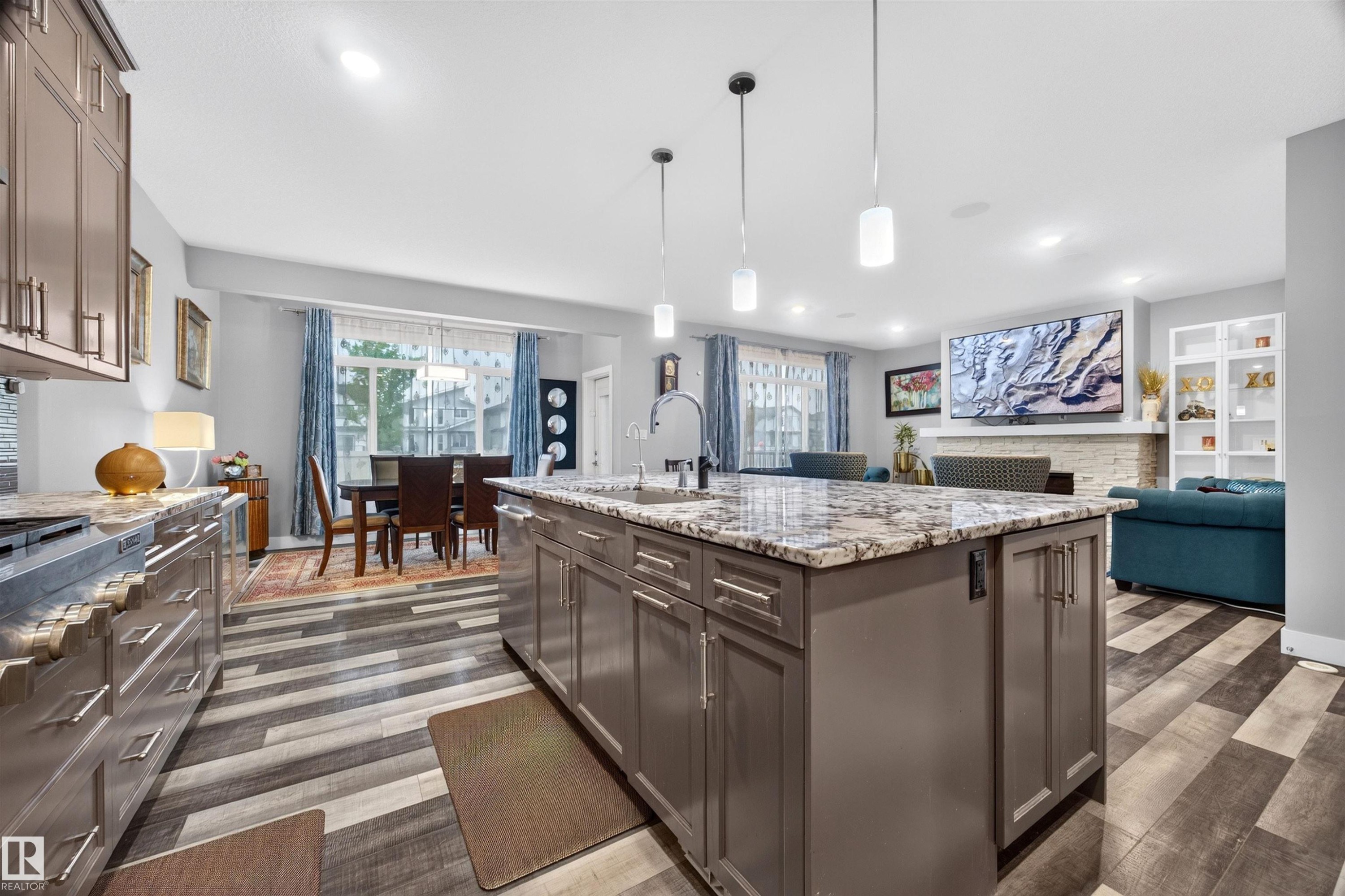 Kitchen island featuring a granite countertop, undermount sink, and pendant lighting - 1603 158 Street, Edmonton, AB