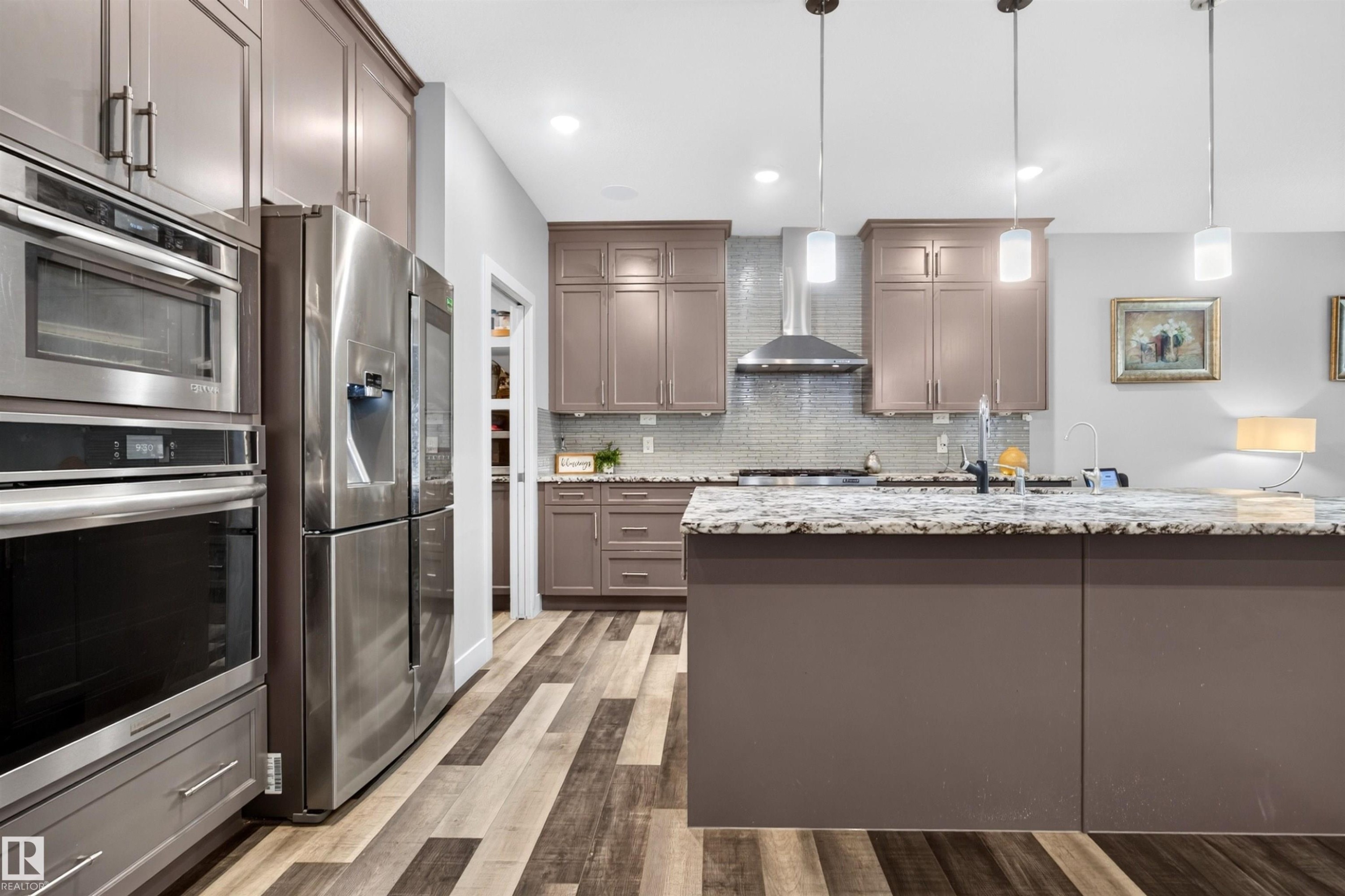 Kitchen featuring wood-finish flooring, recessed lighting, and a large island with a countertop - 1603 158 Street, Edmonton, AB