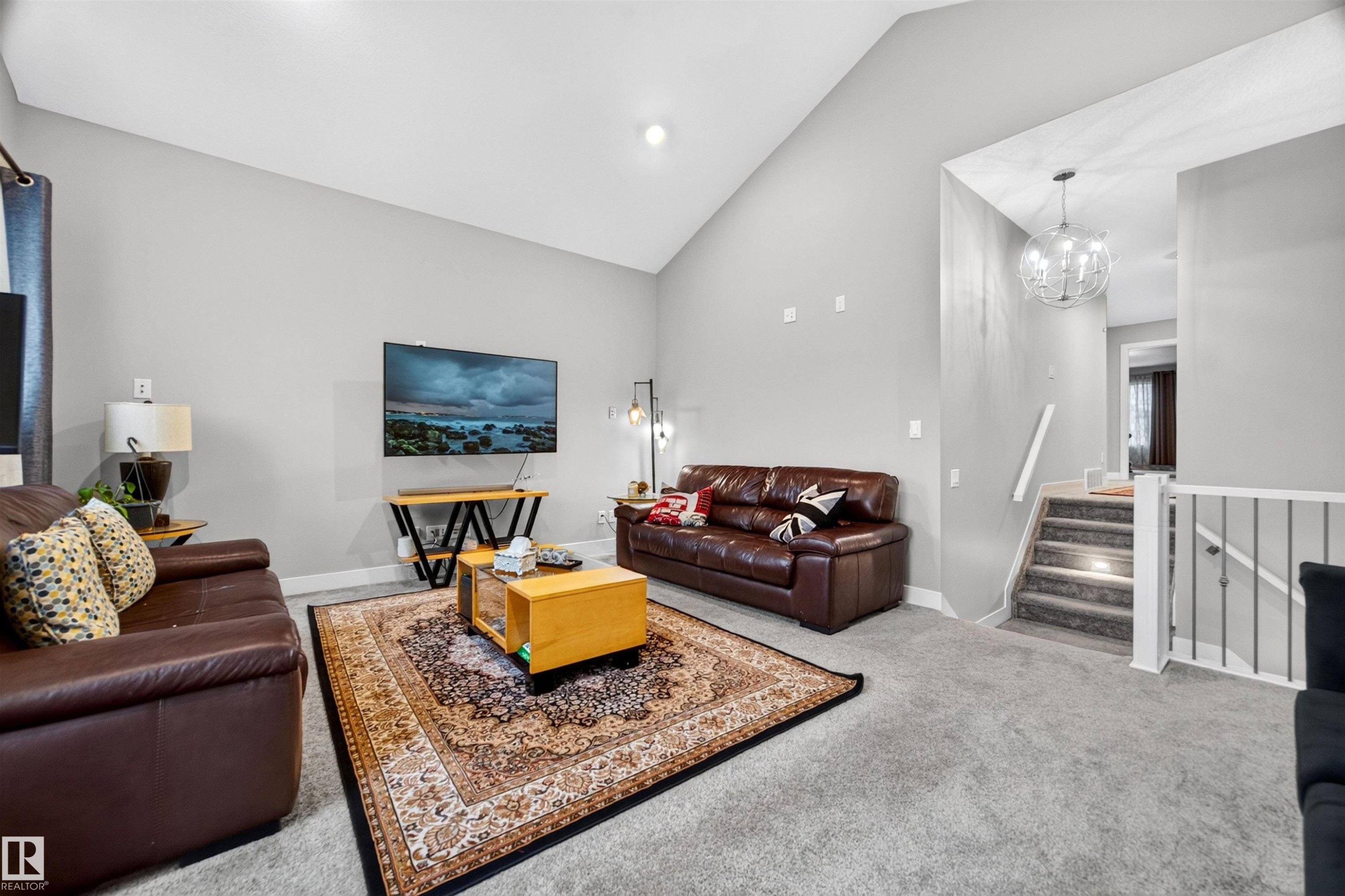 Spacious living area featuring a vaulted ceiling and neutral-toned walls - 1603 158 Street, Edmonton, AB