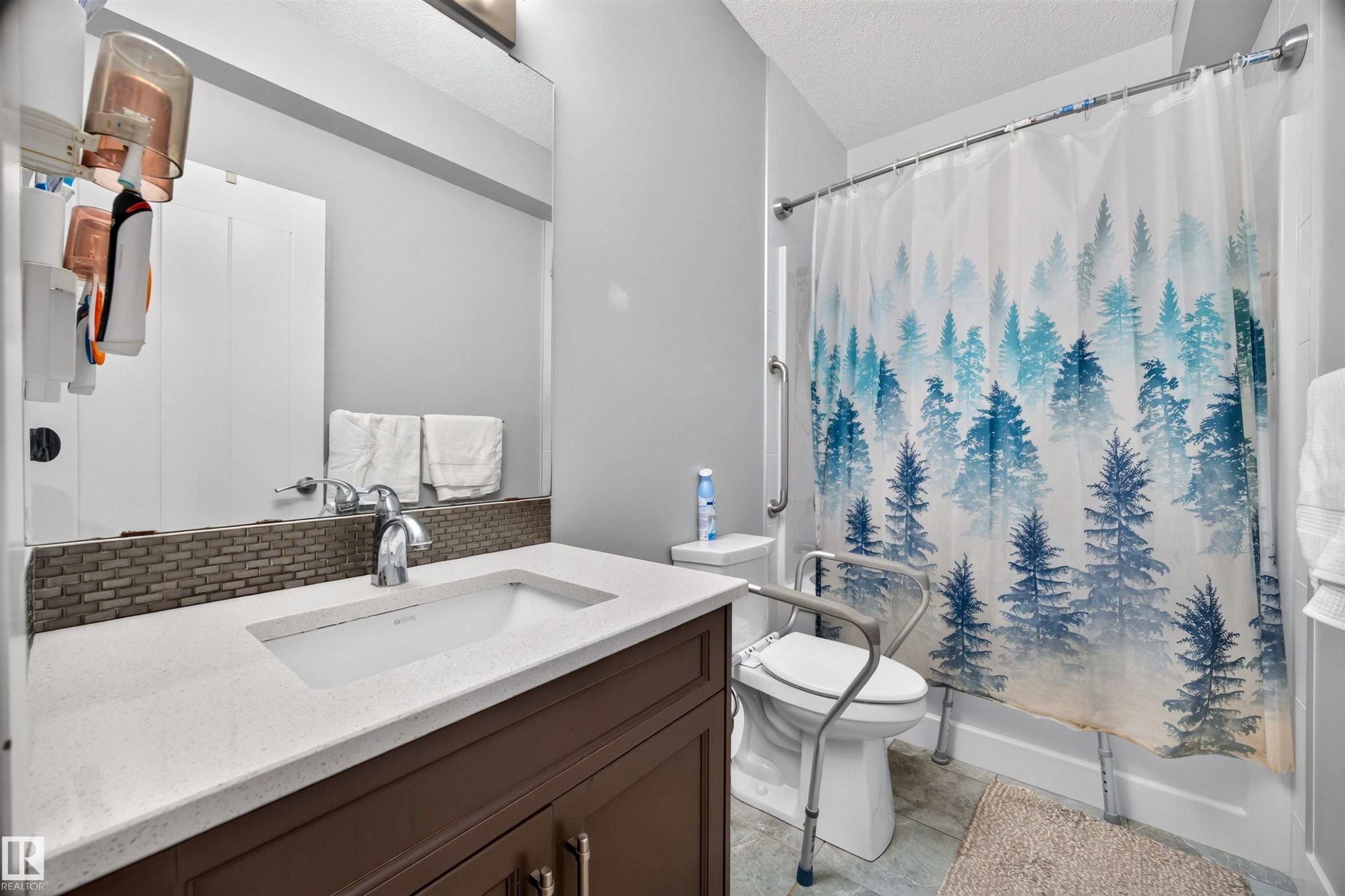 Bathroom with a dark wood-finish vanity, white countertop, and integrated rectangular sink - 1603 158 Street, Edmonton, AB