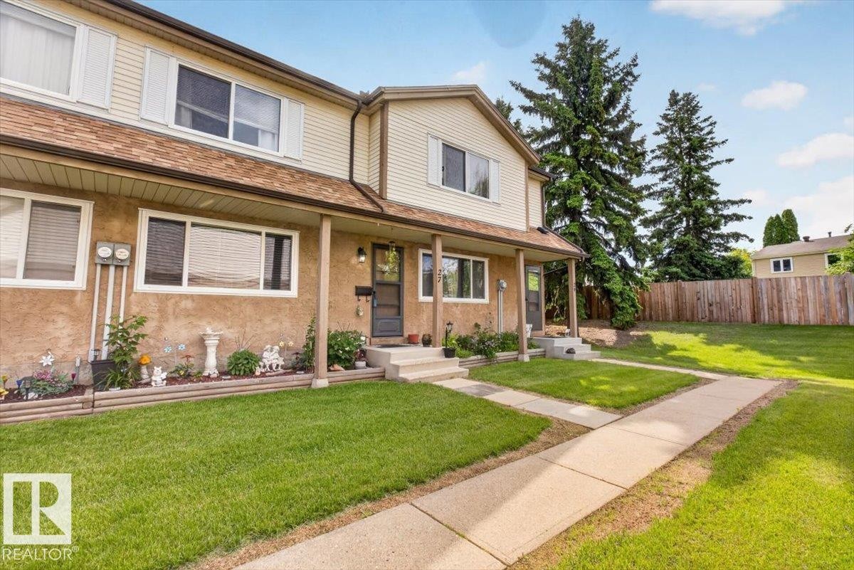 Two-story residential building with light-colored siding and a contrasting brown roof - 27 Walden Park, St. Albert, AB