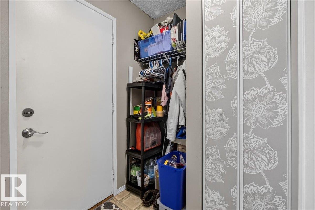 Bi-fold closet doors featuring a decorative floral pattern - 27 Walden Park, St. Albert, AB
