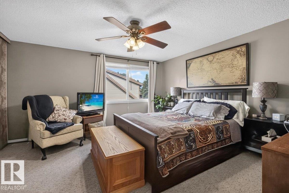 Carpeted room featuring a ceiling fan with integrated lighting, a window with vertical blinds, and neutral-toned walls - 27 Walden Park, St. Albert, AB