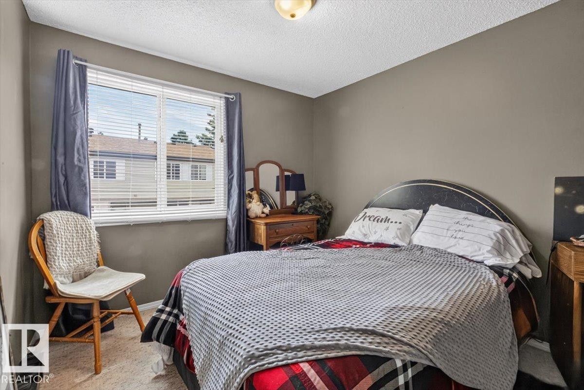 Carpeted room with a large window featuring horizontal blinds - 27 Walden Park, St. Albert, AB