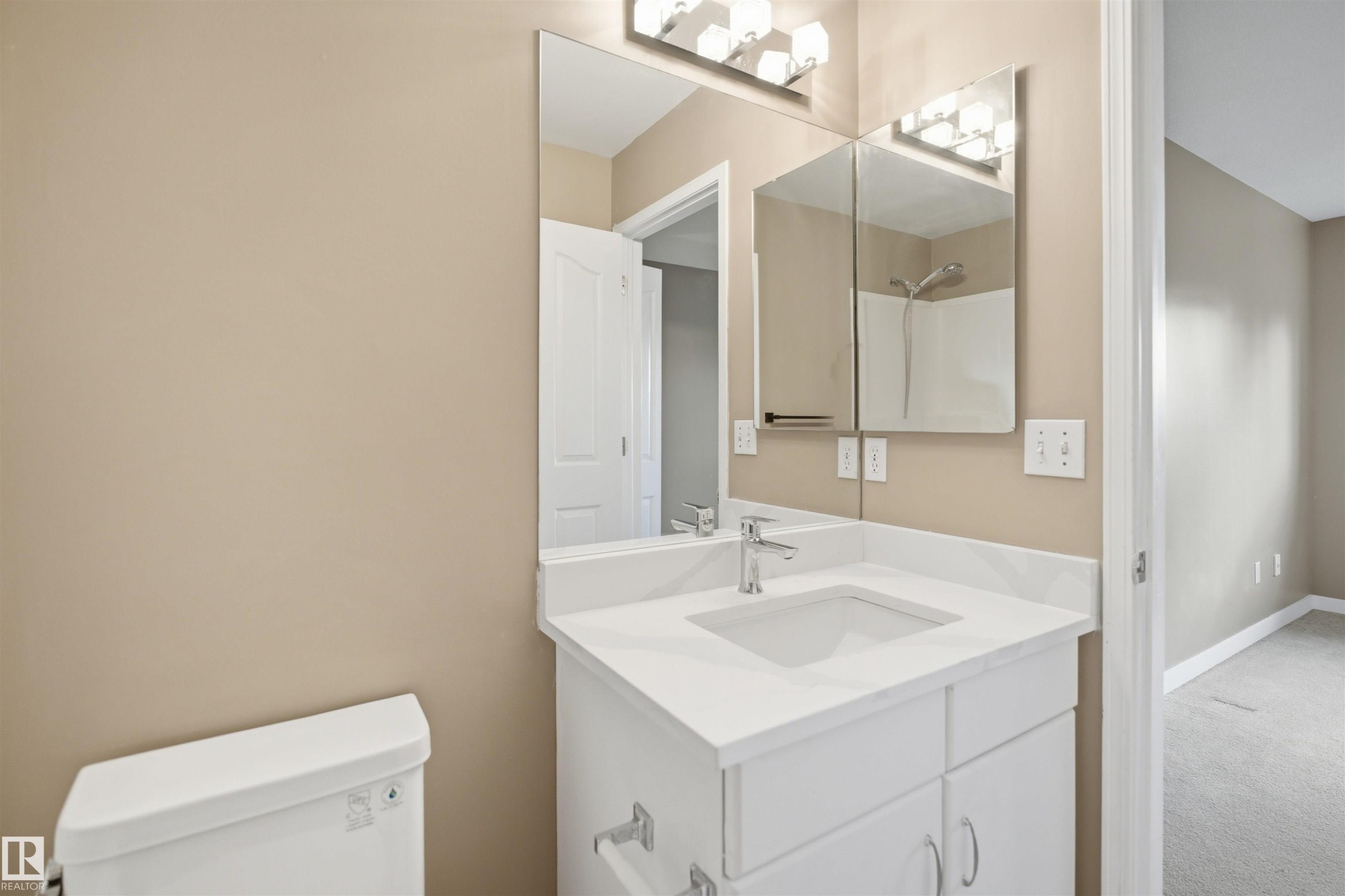 Bathroom vanity featuring a white countertop with an integrated sink and chrome faucet - 2610 33A Street, Edmonton, AB - Indoor Photo Showing Bathroom