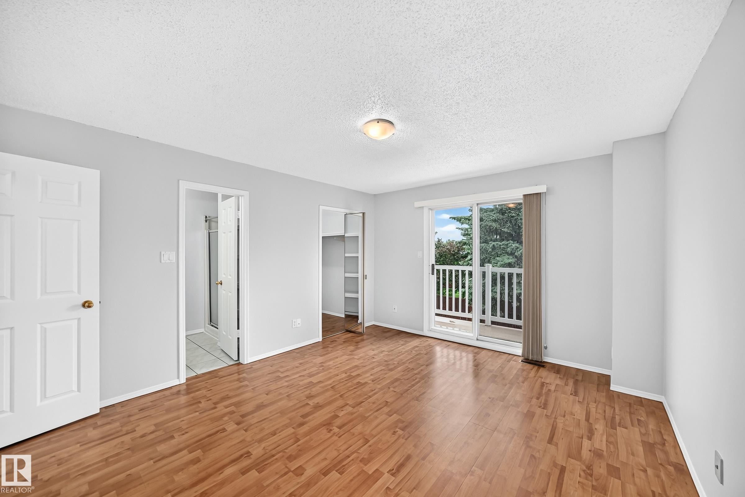 Room featuring wood-finish flooring, light grey walls, and a white ceiling - 9843 188 Street, Edmonton, AB