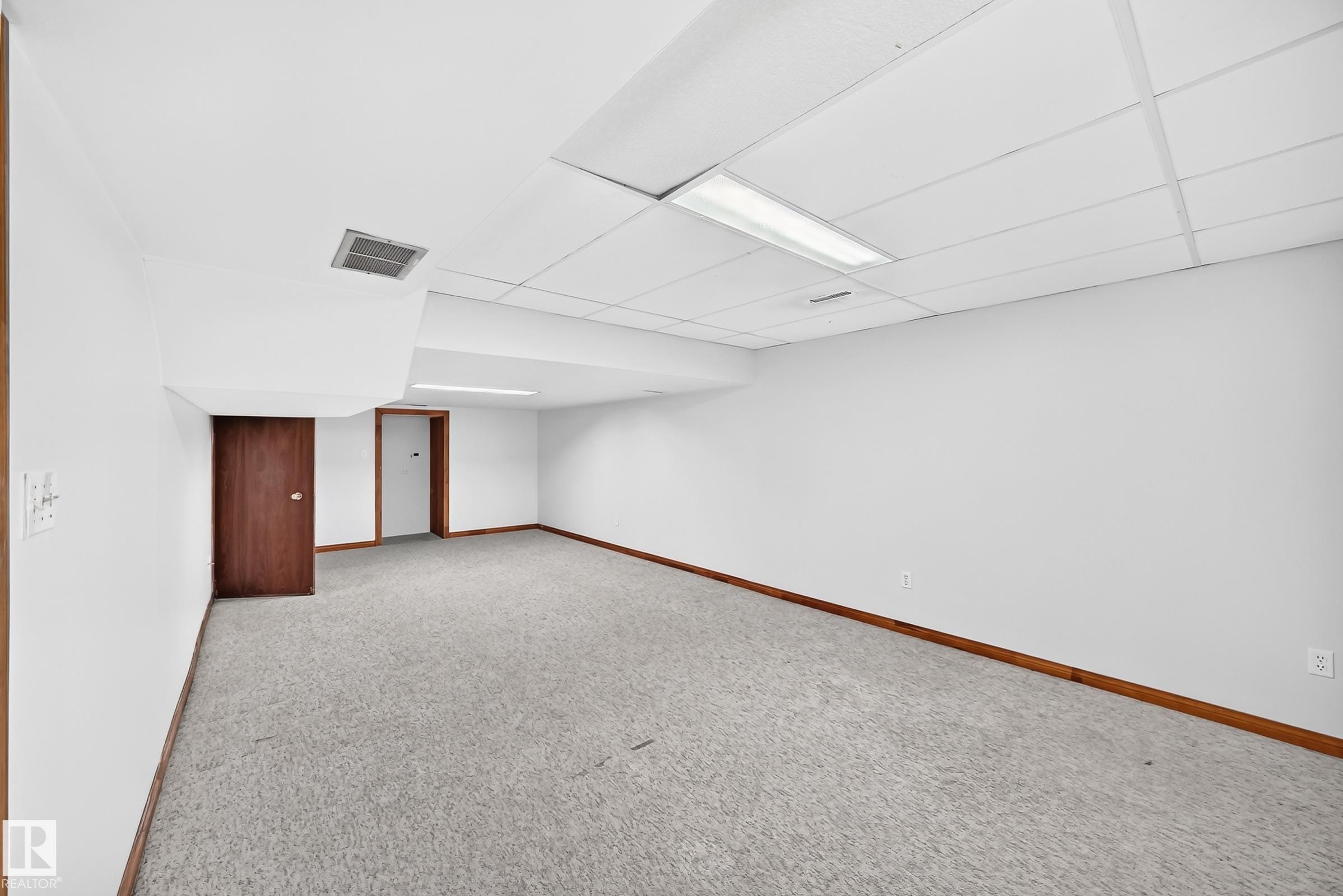 Spacious room featuring light gray carpeting, white walls, and wood trim - 9843 188 Street, Edmonton, AB