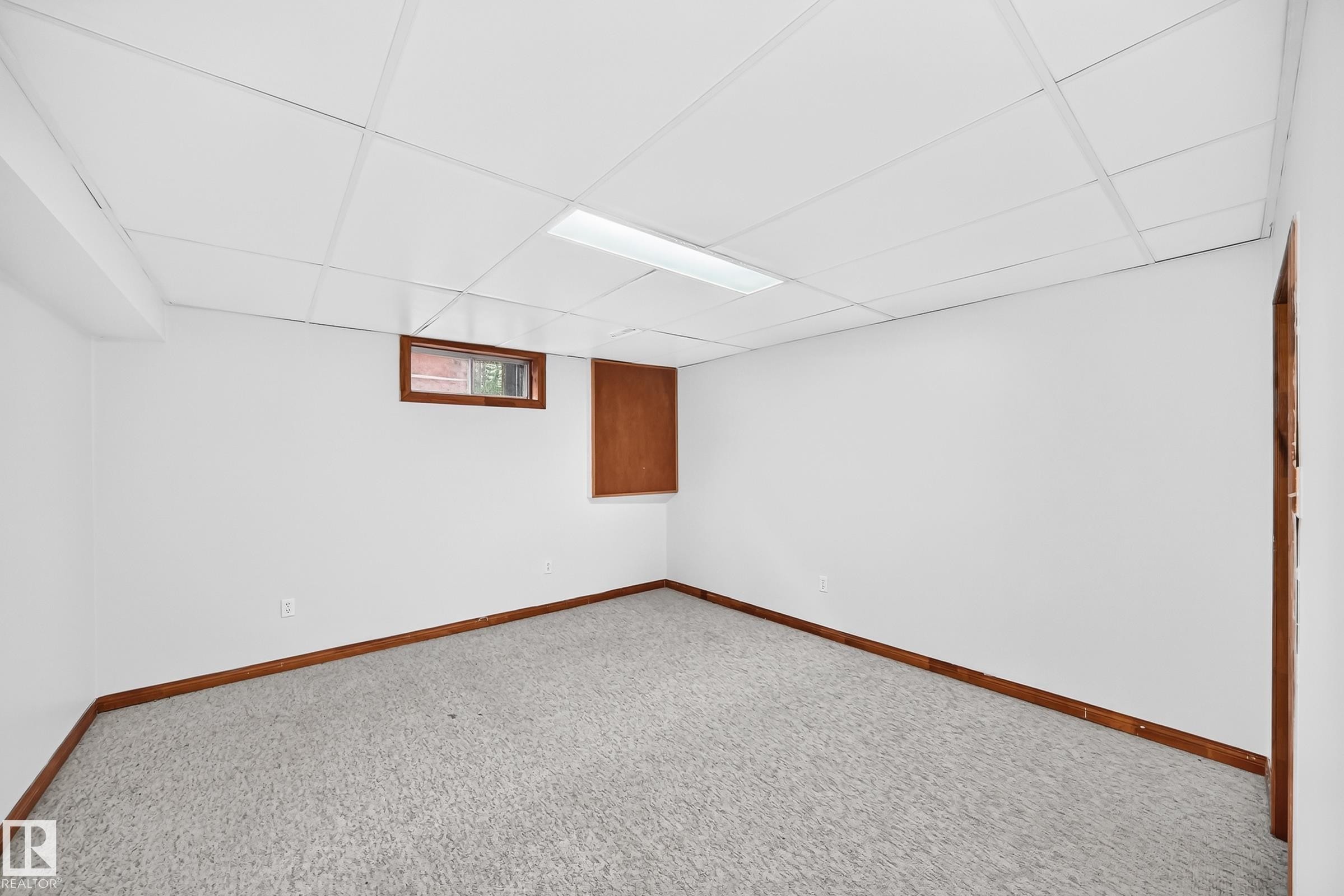 Carpeted room featuring white walls, wood-finish baseboards, and a drop ceiling with recessed lighting - 9843 188 Street, Edmonton, AB