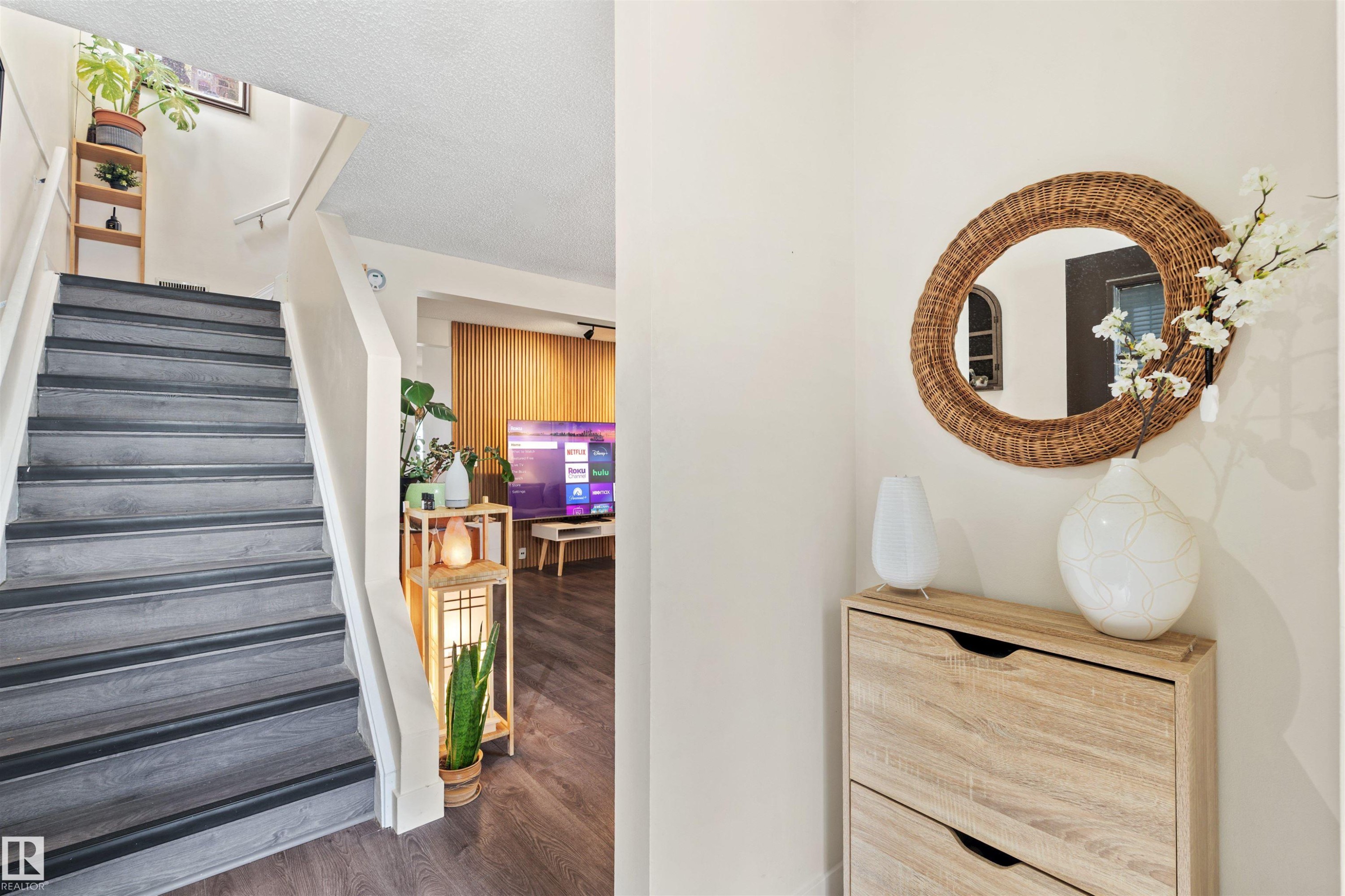 Staircase featuring dark wood-finish treads and white risers, complemented by white walls and wood-finish flooring - 359 Kirkpatrick Crescent, Edmonton, AB