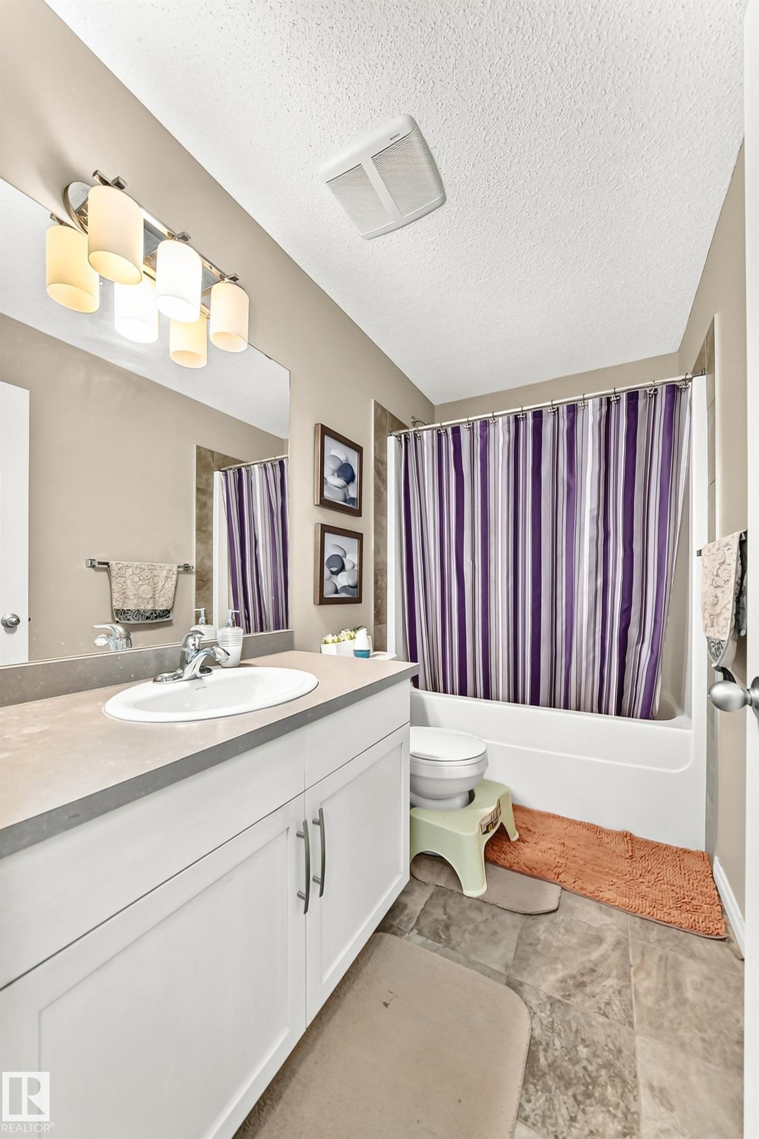 Bathroom featuring a white vanity with a light gray countertop, a polished chrome faucet, an integrated sink, and wood-finish flooring - 875 Chappelle Link Link Sw, Edmonton, AB