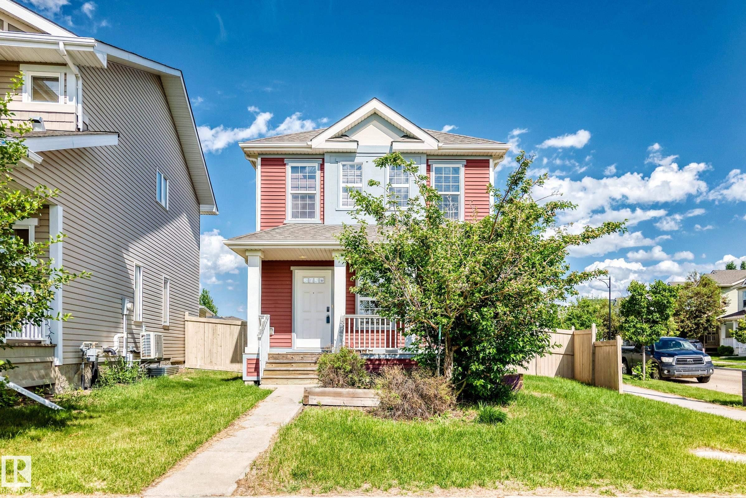 Two-story residence featuring a covered front porch with white railings and columns - 875 Chappelle Link Link Sw, Edmonton, AB