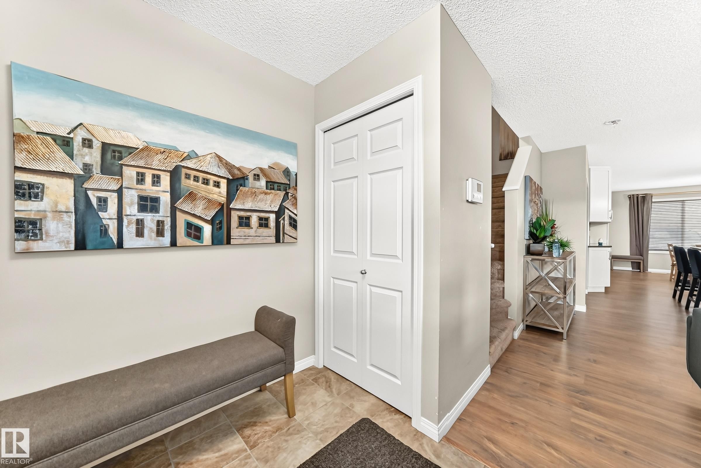 Entryway featuring bi-fold closet doors, neutral wall tones, and mixed flooring - 875 Chappelle Link Link Sw, Edmonton, AB