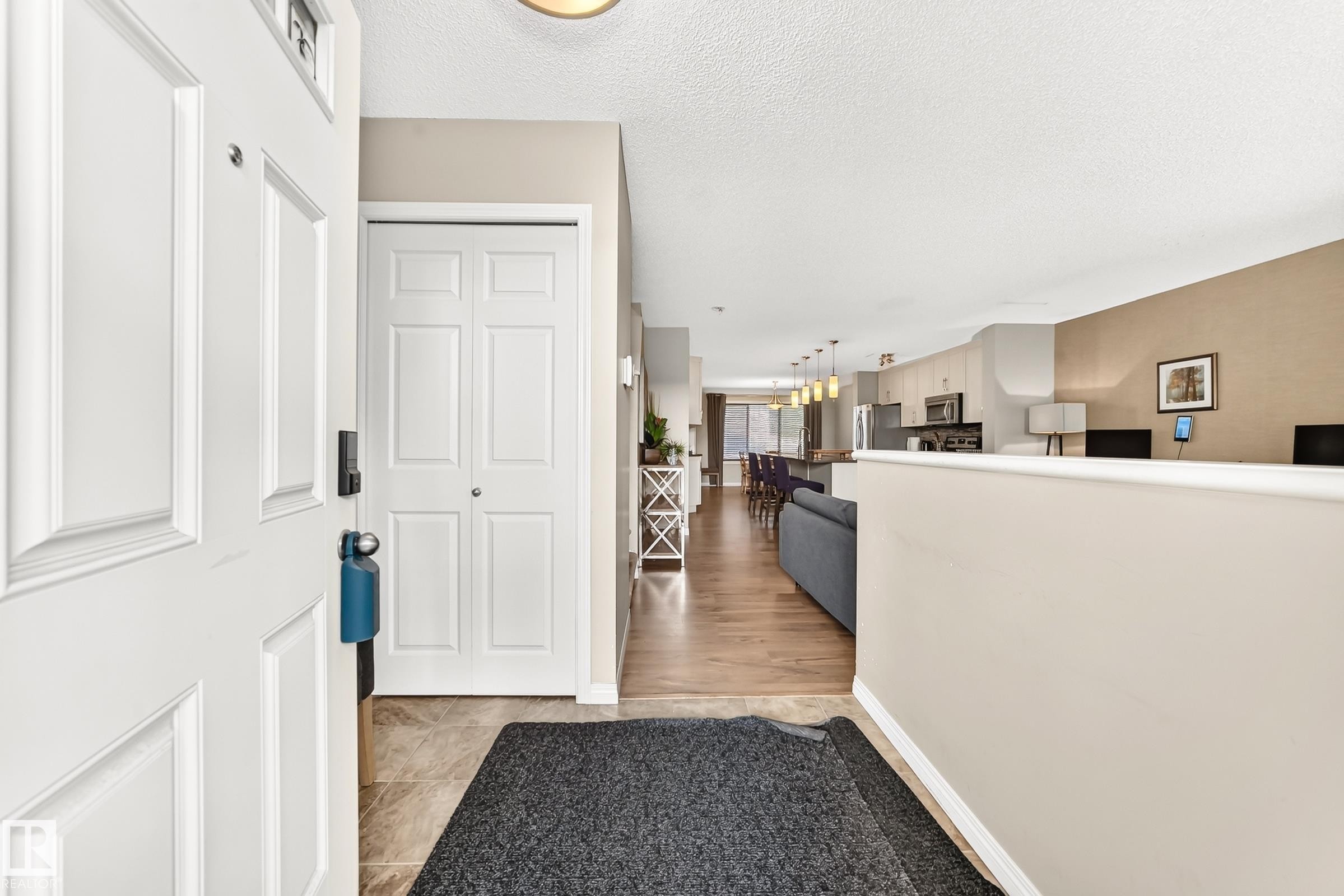 Inviting entryway with tile flooring transitioning to wood-finish flooring - 875 Chappelle Link Link Sw, Edmonton, AB