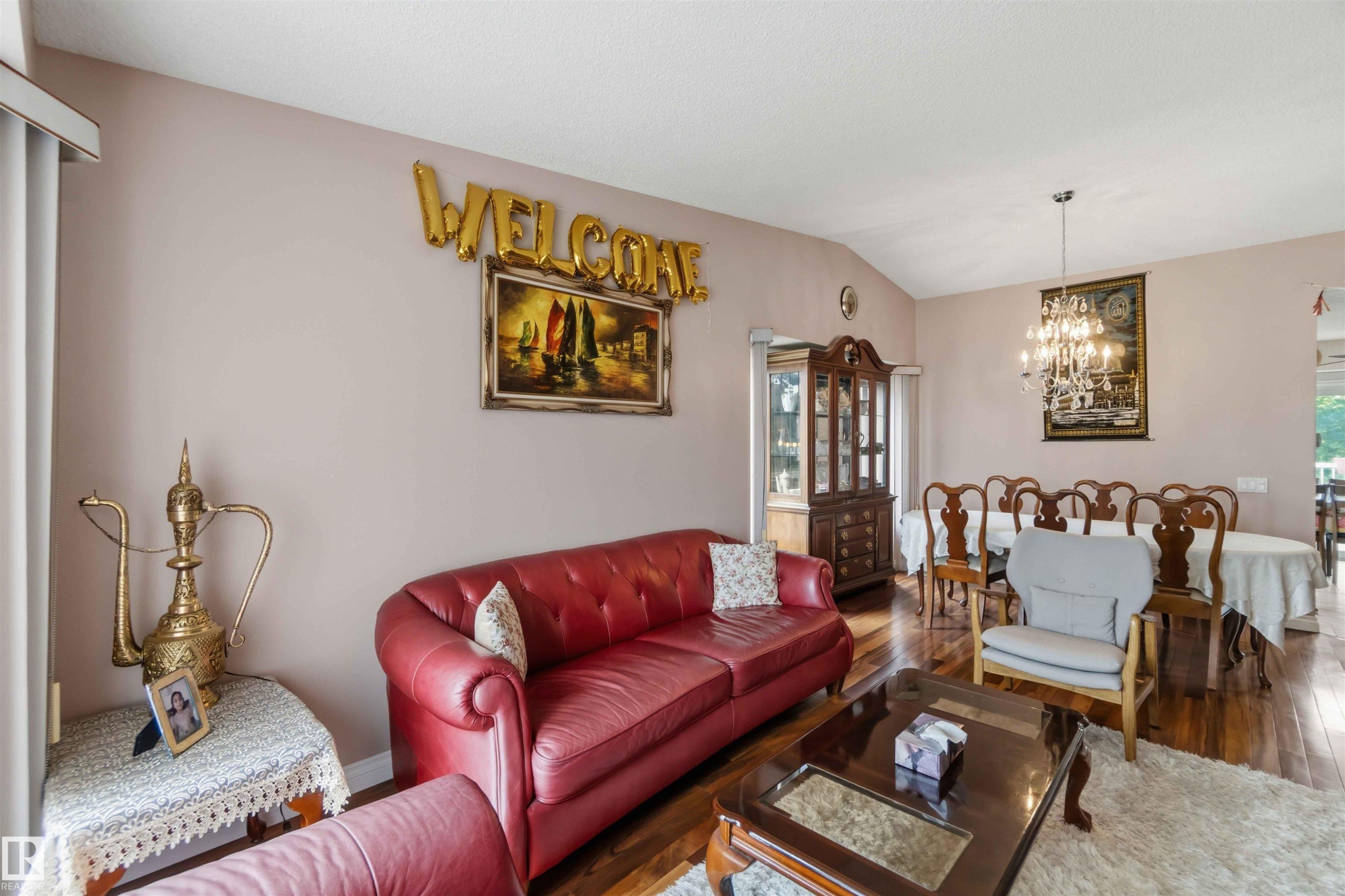 Spacious living area featuring vaulted ceilings, wood-finish flooring, and a formal dining area - 4428 11A Avenue Nw, Edmonton, AB - Indoor Photo Showing Living Room