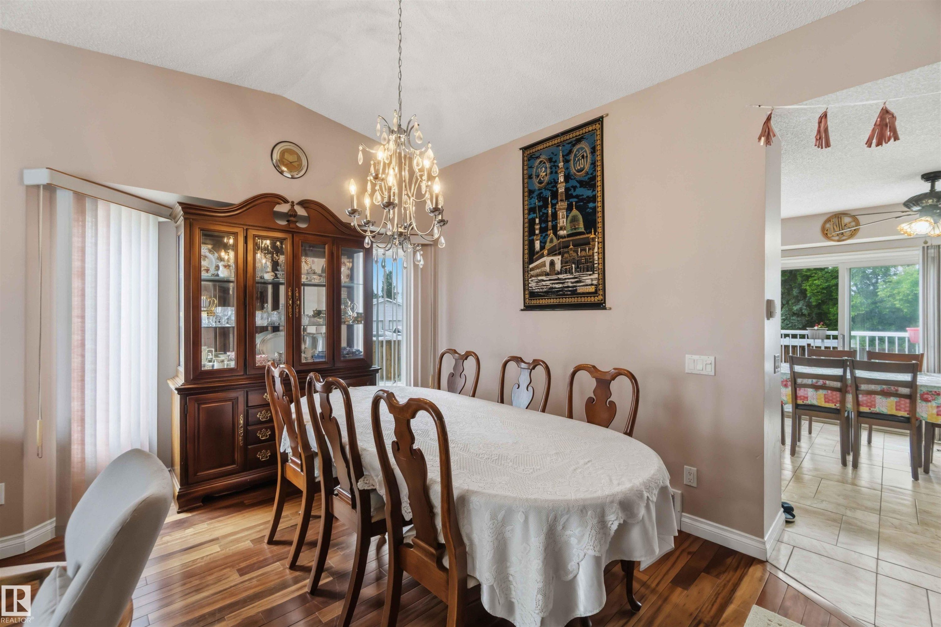 Dining area featuring wood-finish flooring, a vaulted ceiling, and a prominent chandelier - 4428 11A Avenue Nw, Edmonton, AB - Indoor Photo Showing Dining Room