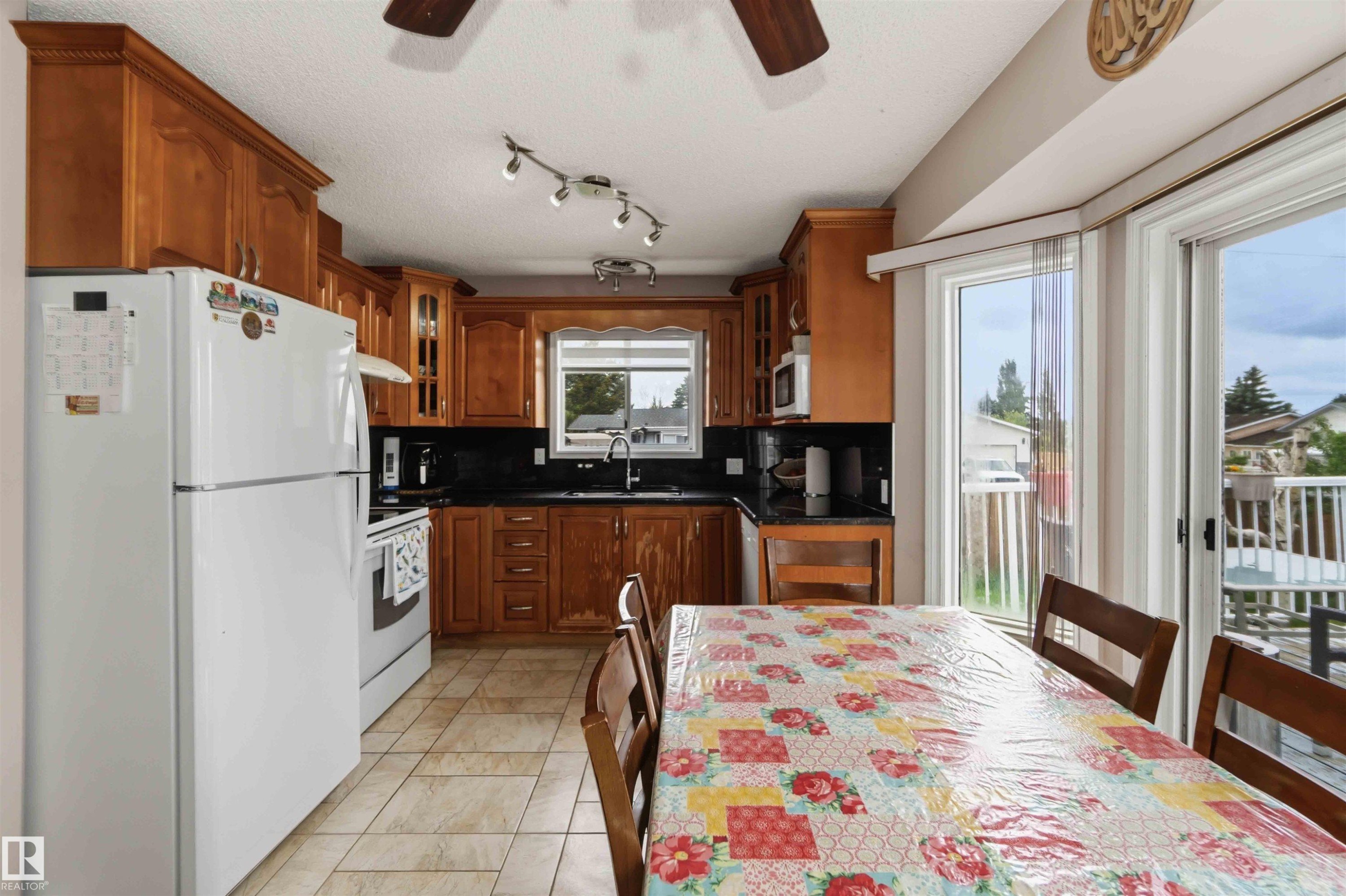 Kitchen featuring wood cabinetry, dark countertops, and tile flooring - 4428 11A Avenue Nw, Edmonton, AB - Indoor