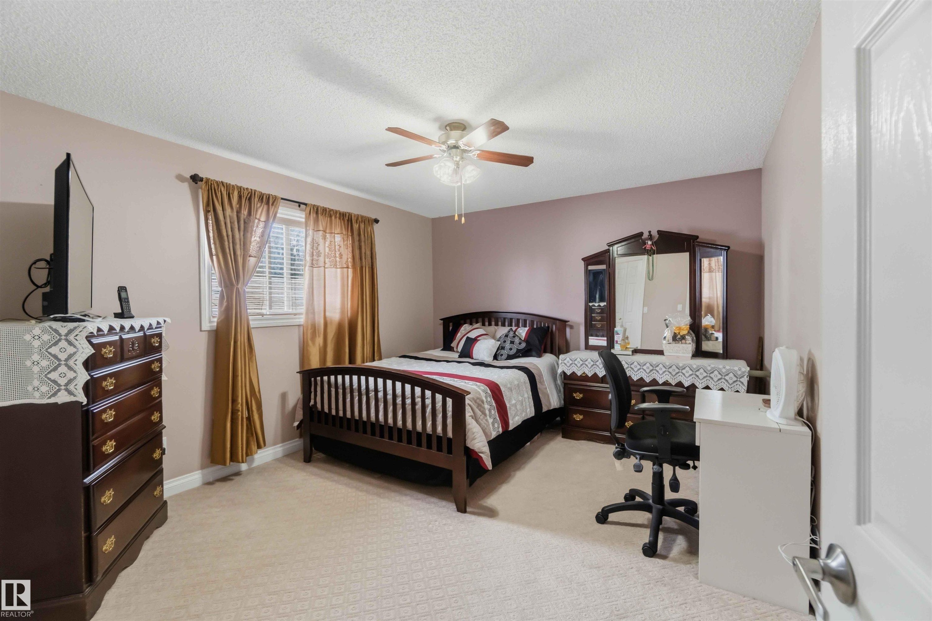Carpeted bedroom featuring a ceiling fan, window with blinds, and white baseboards - 4428 11A Avenue Nw, Edmonton, AB - Indoor Photo Showing Bedroom