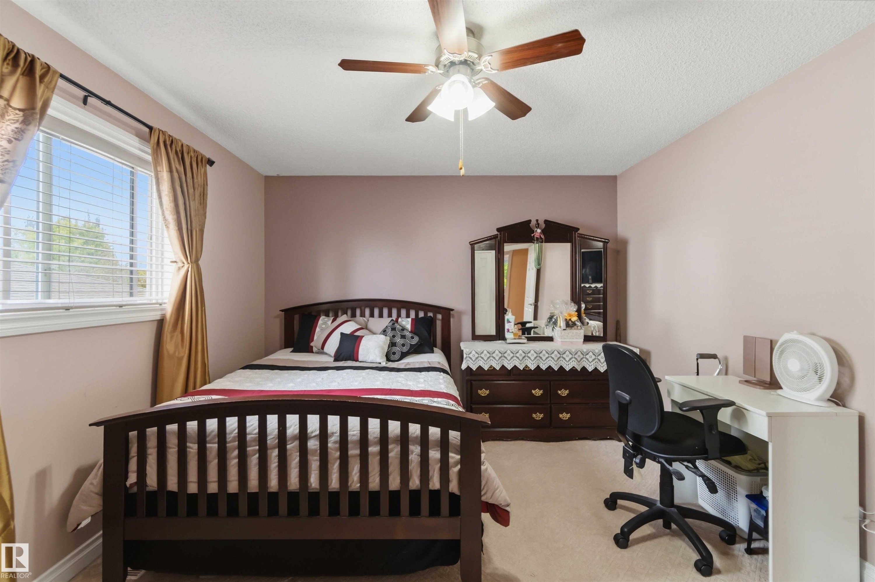 Recessed window with blinds and drapes, ceiling fan with light fixture, carpet flooring, and painted walls - 4428 11A Avenue Nw, Edmonton, AB - Indoor Photo Showing Bedroom