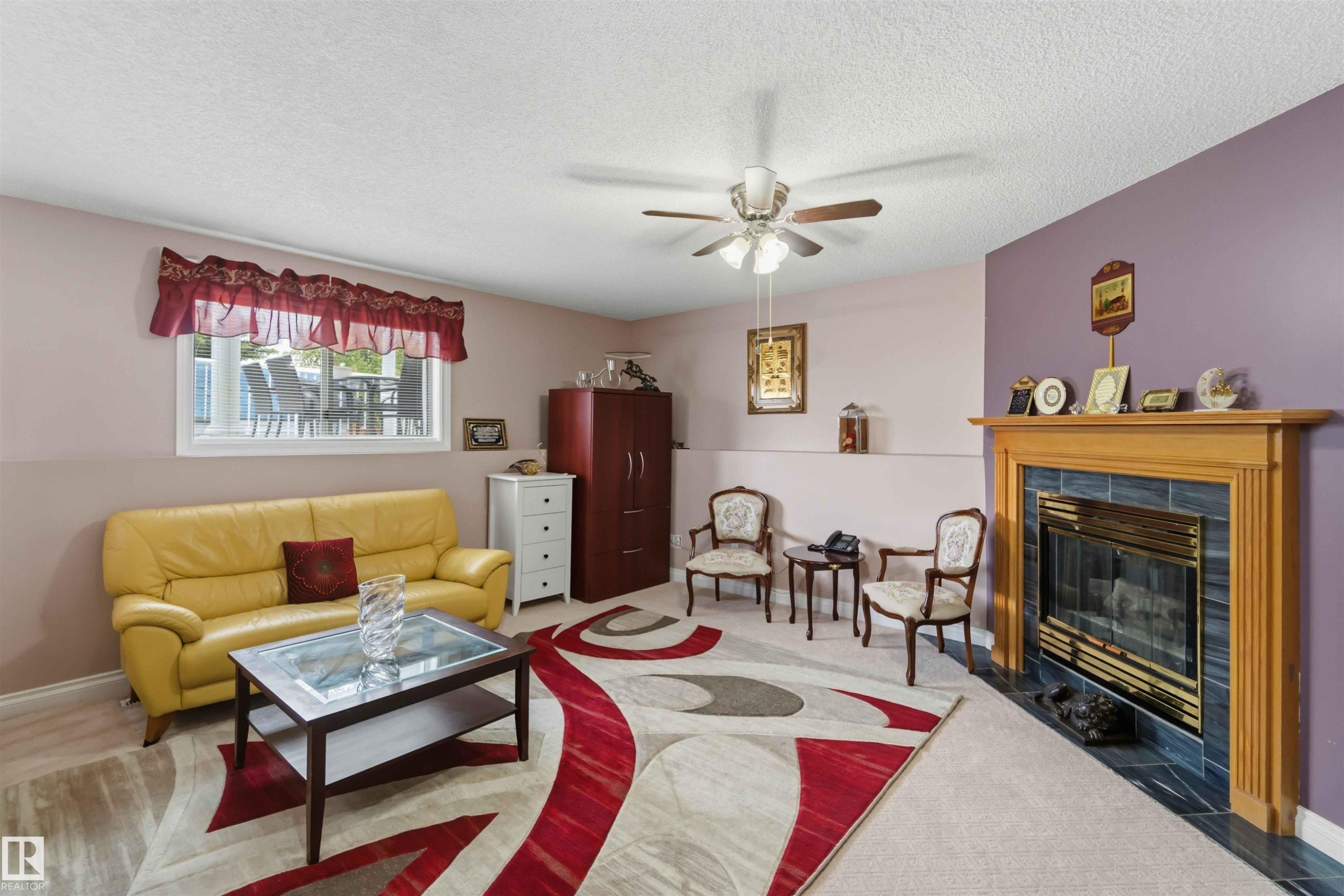 Living area featuring a fireplace with a wood mantel and tile surround - 4428 11A Avenue Nw, Edmonton, AB - Indoor Photo Showing Living Room With Fireplace