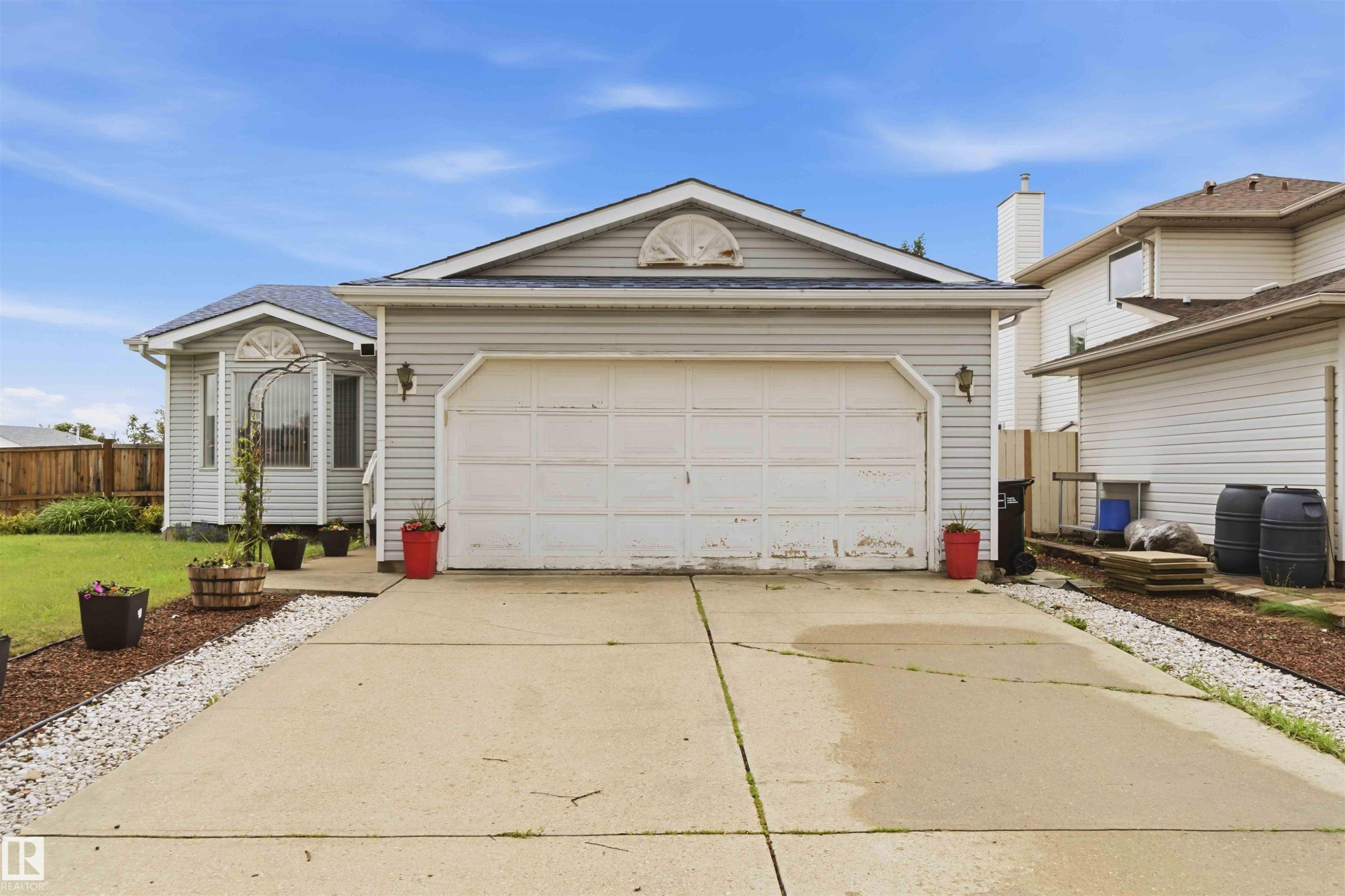 Exterior featuring light gray siding, an attached two-car garage, a bay window, and a concrete driveway - 4428 11A Avenue Nw, Edmonton, AB - Outdoor