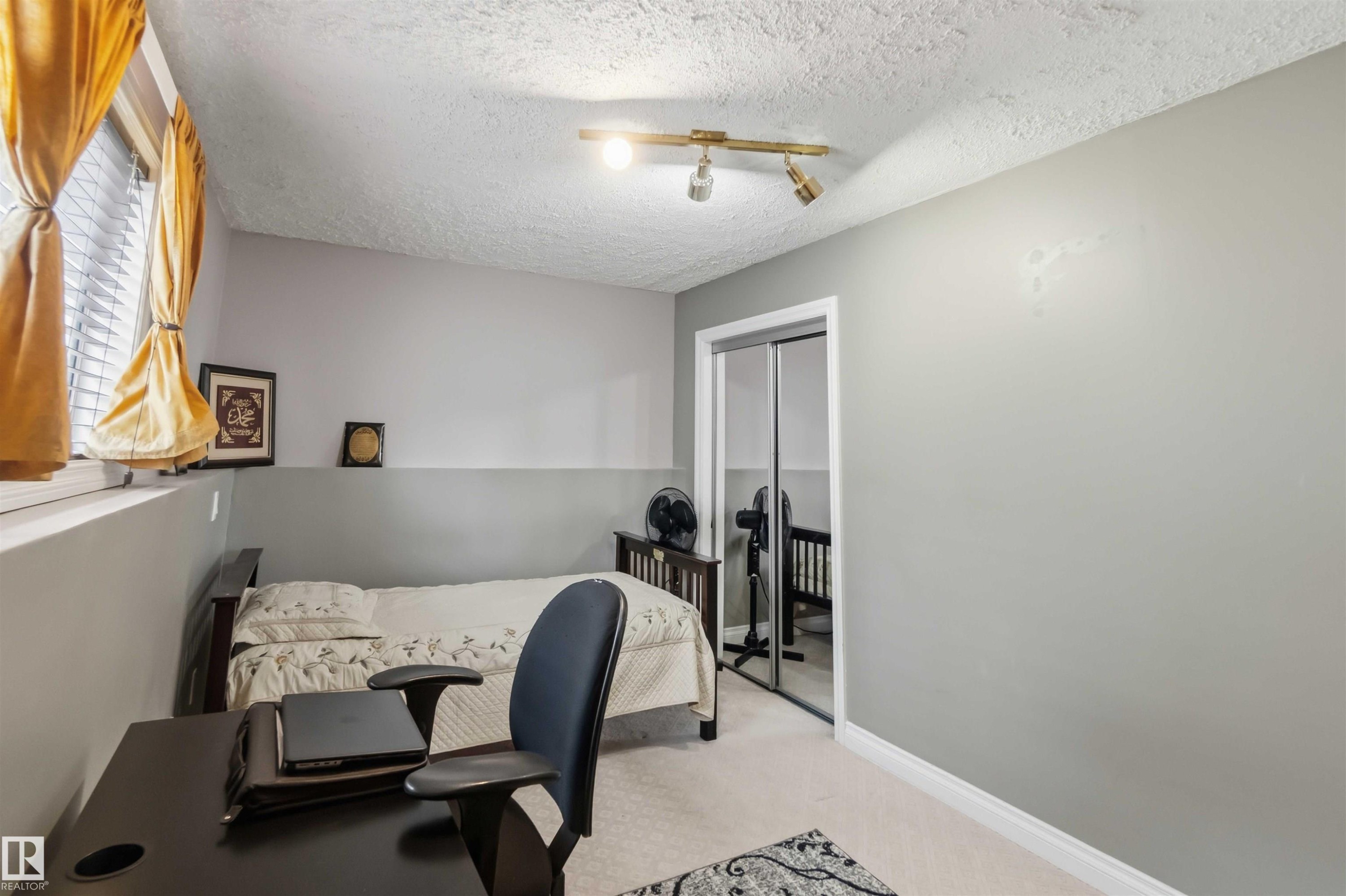 Interior room with track lighting, light-colored walls, and a window with blinds - 4428 11A Avenue Nw, Edmonton, AB - Indoor