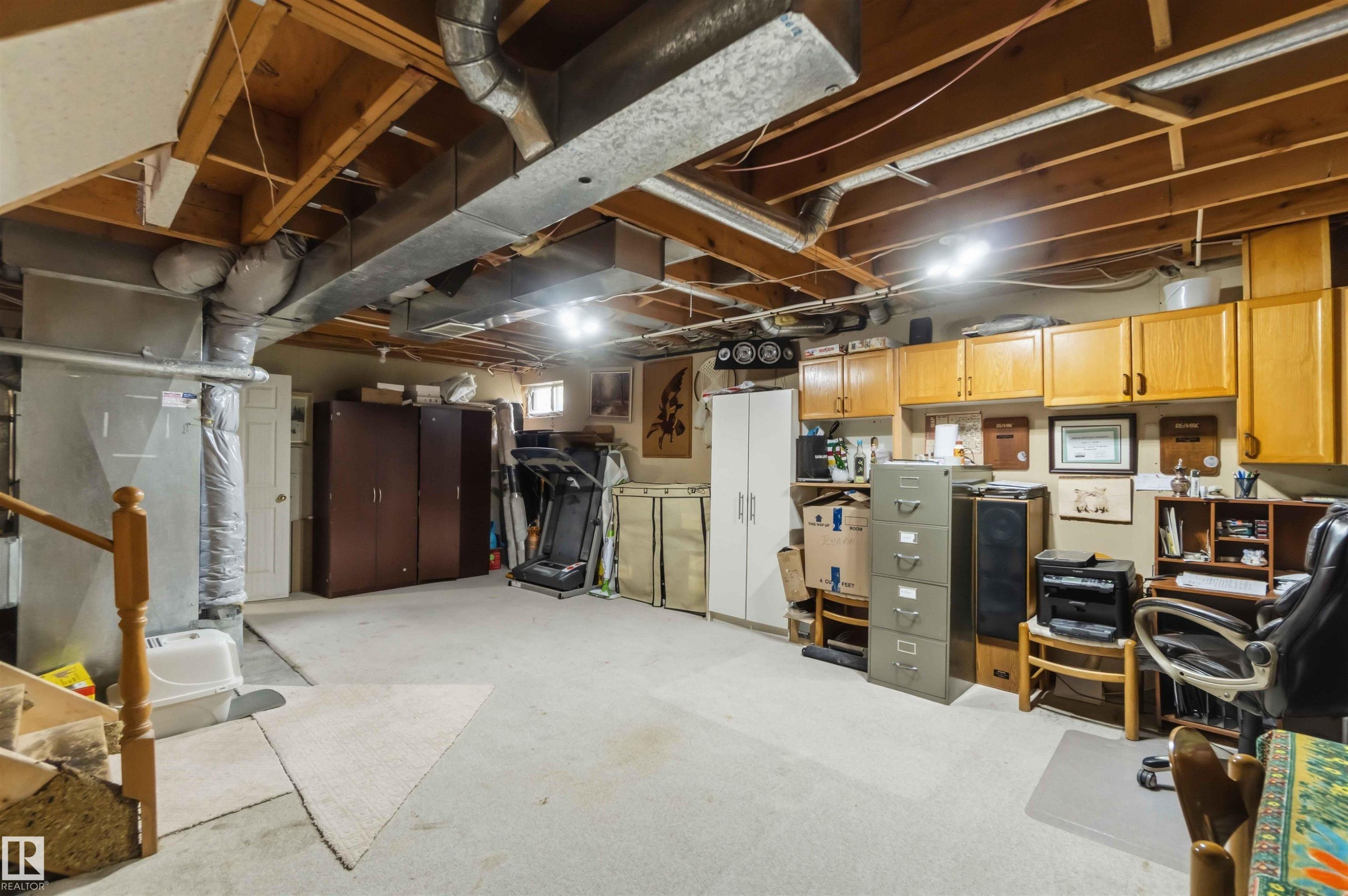 Spacious unfinished basement offering exposed ceiling joists and ductwork, multiple recessed light fixtures, built-in cabinetry, and a carpeted floor - 4428 11A Avenue Nw, Edmonton, AB - Indoor Photo Showing Basement