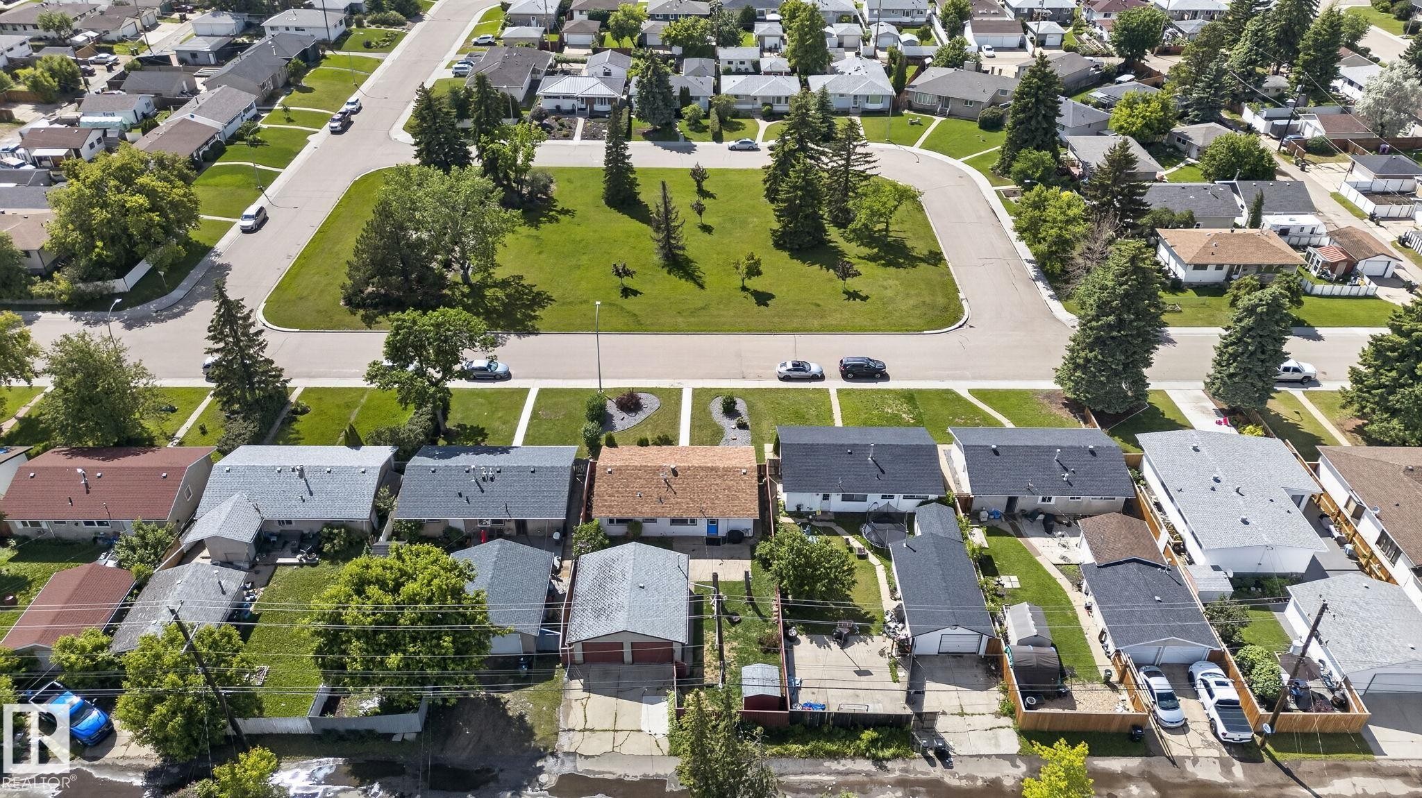 Residential neighborhood featuring a cul-de-sac with a central green space, mature trees, and paved roads - 13431 109 Street, Edmonton, AB