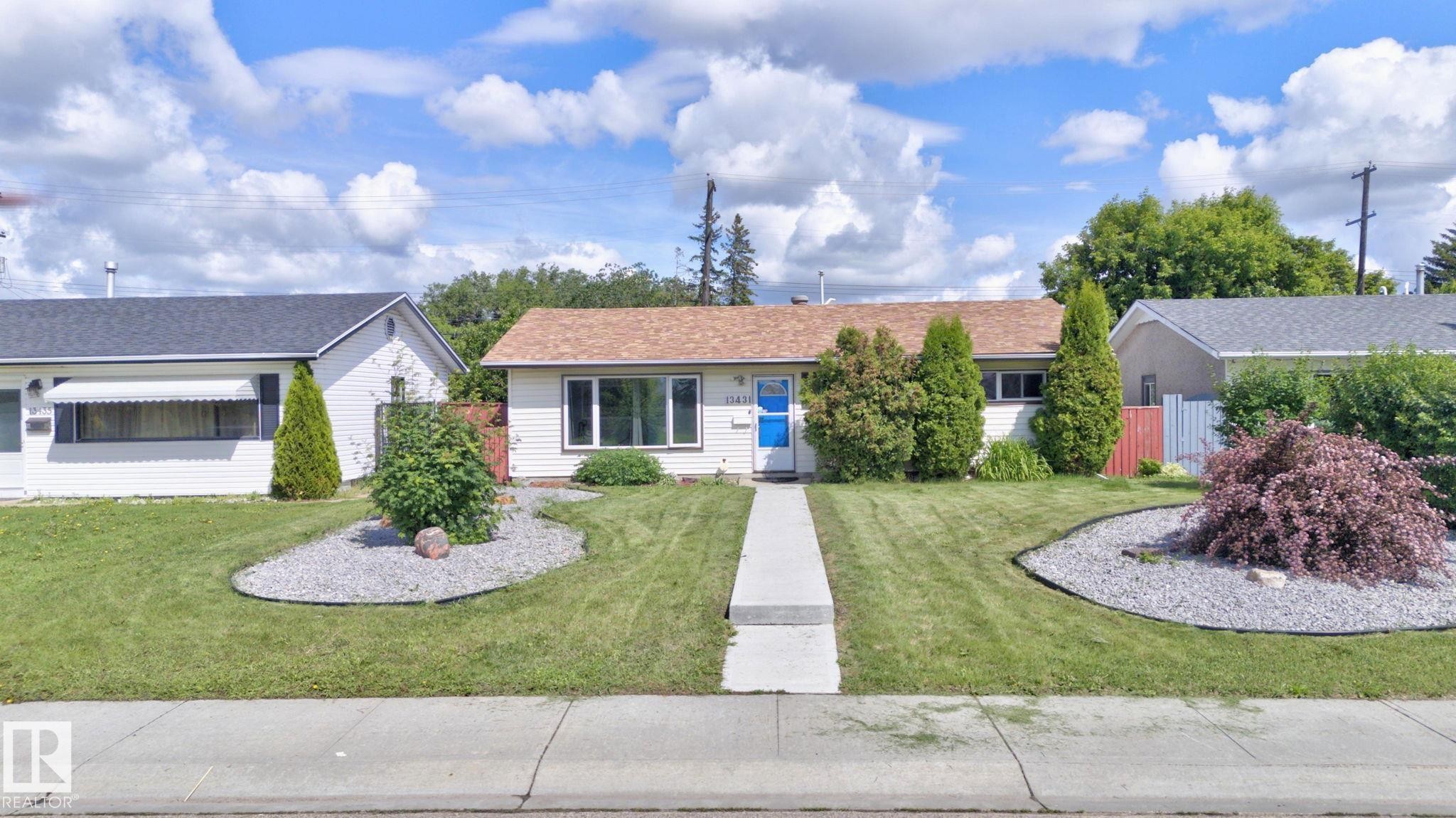 Single-story residence featuring a front lawn with a central concrete pathway, decorative gravel beds, and established landscaping - 13431 109 Street, Edmonton, AB