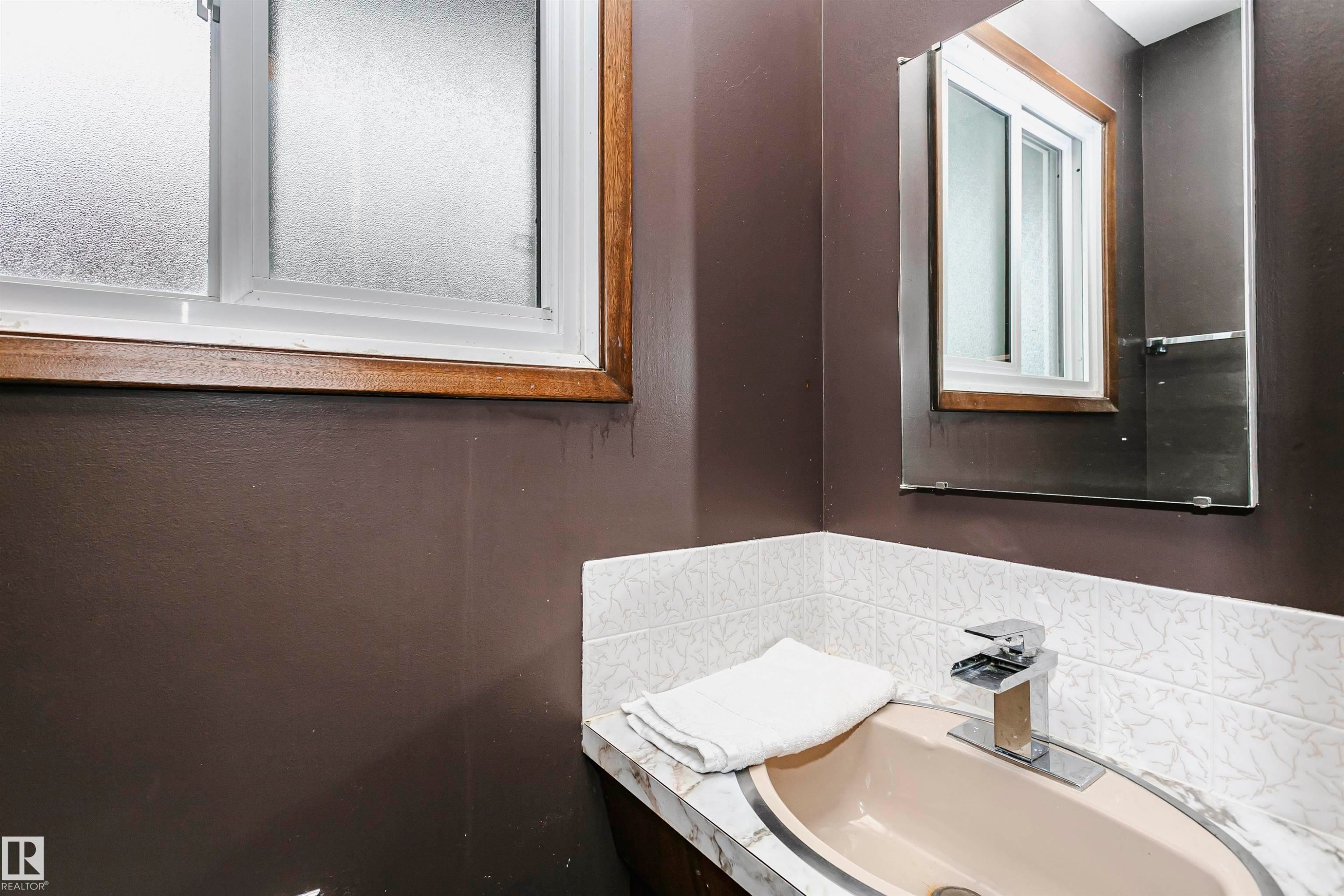 Bathroom vanity featuring a beige oval sink with a chrome faucet - 14231 80 Street, Edmonton, AB