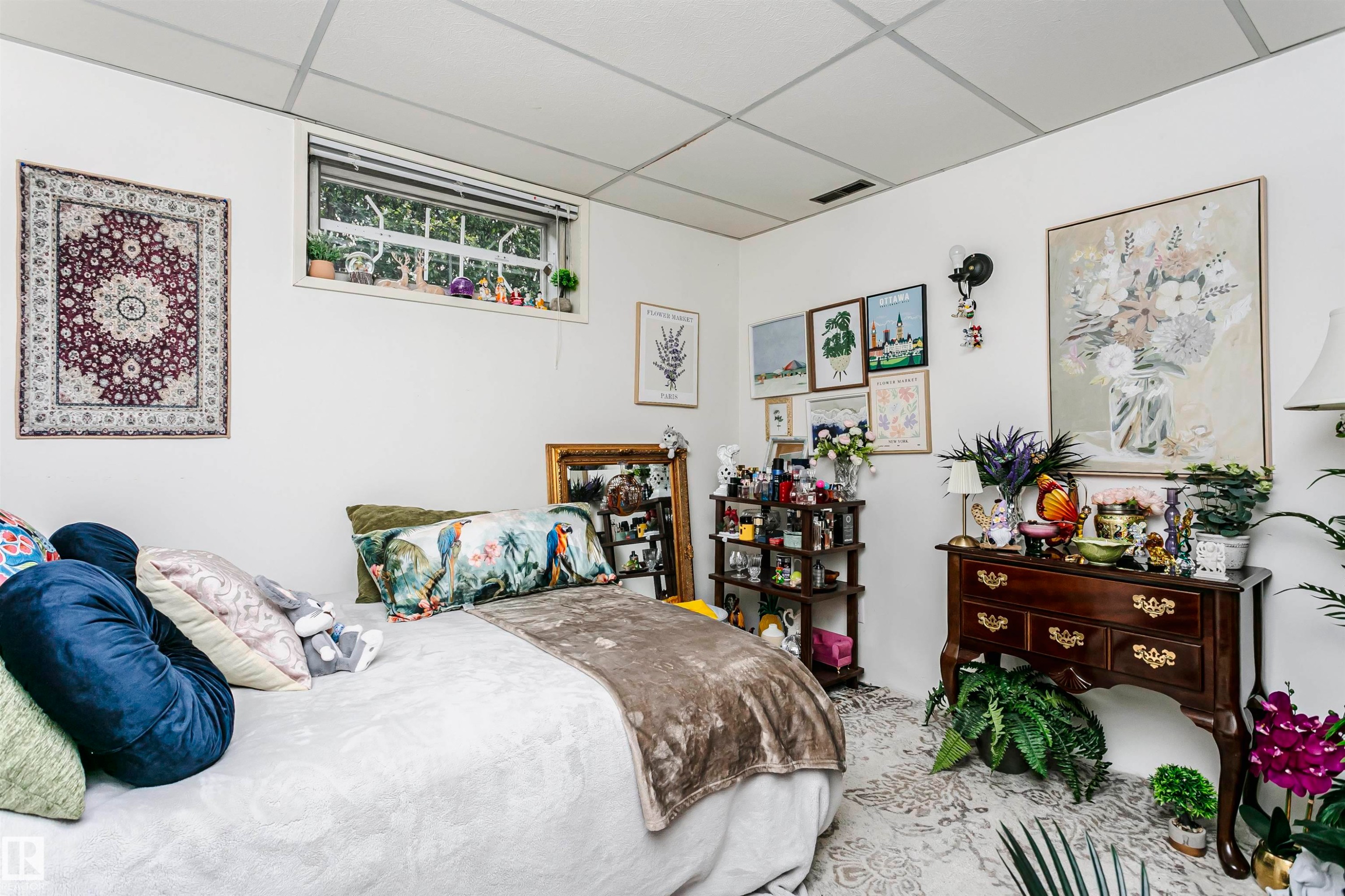 White walls offer a neutral canvas in this room featuring a window with natural light, a drop ceiling, and a built-in wall sconce - 14231 80 Street, Edmonton, AB