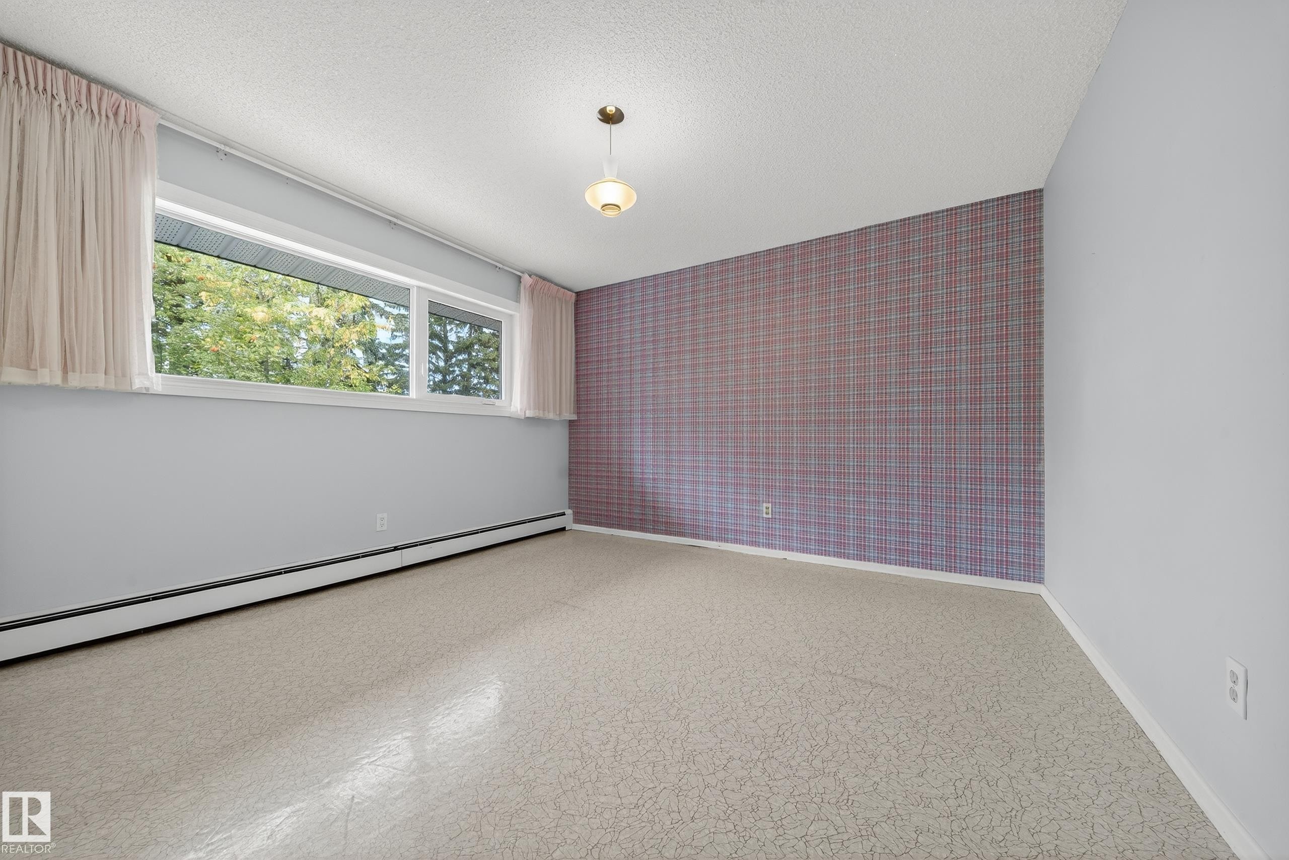 Bright interior space with patterned flooring and a large horizontal window - 707 65 Avenue, Edmonton, AB