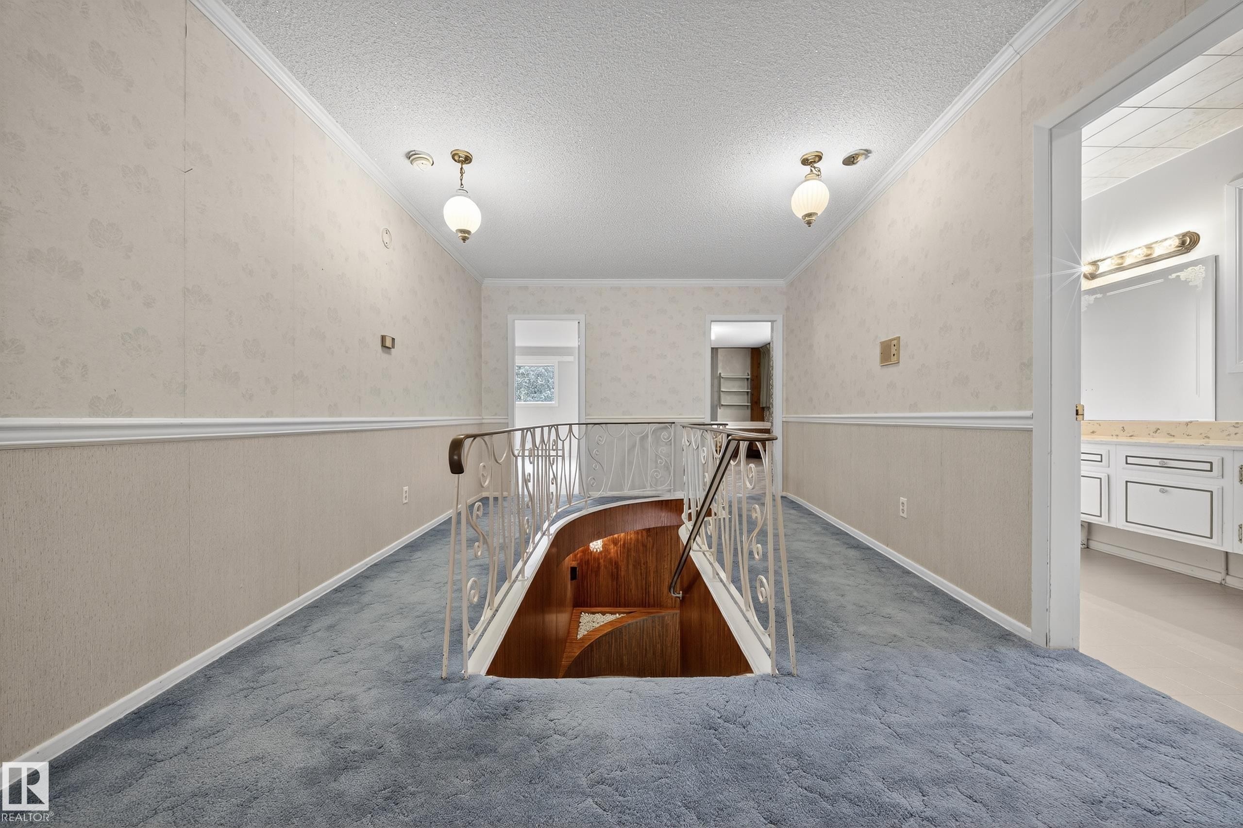 Upper-level hallway with blue carpeting and wallpapered walls - 707 65 Avenue, Edmonton, AB